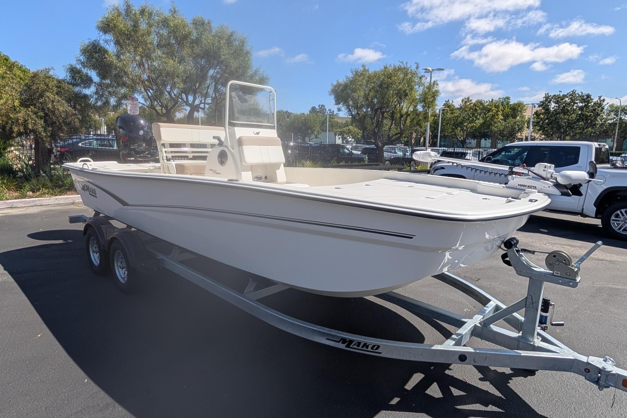 2026 Mako Pro Skiff 19 CC boat on trailer, parked outdoors under clear sky.