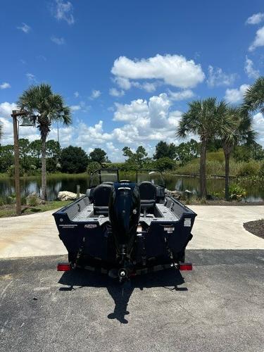 2025 Bass Tracker PGV16WT boat parked near a scenic lake with palm trees.