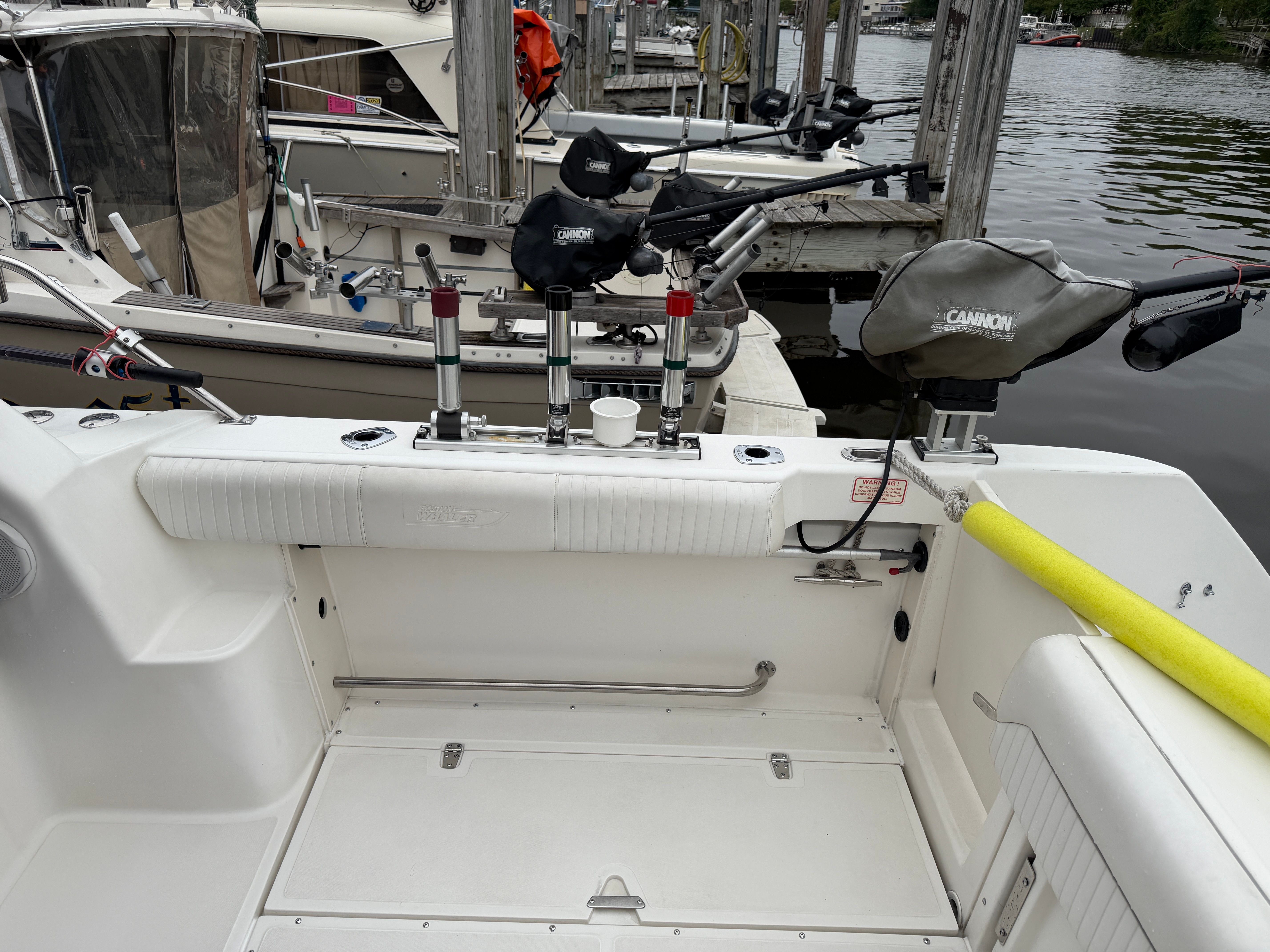 The image shows the cockpit of a 2001 Boston Whaler 26 Conquest docked at a pier.