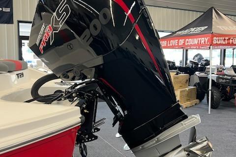 2025 Tahoe T21 boat with powerful outboard motor in showroom setting.
