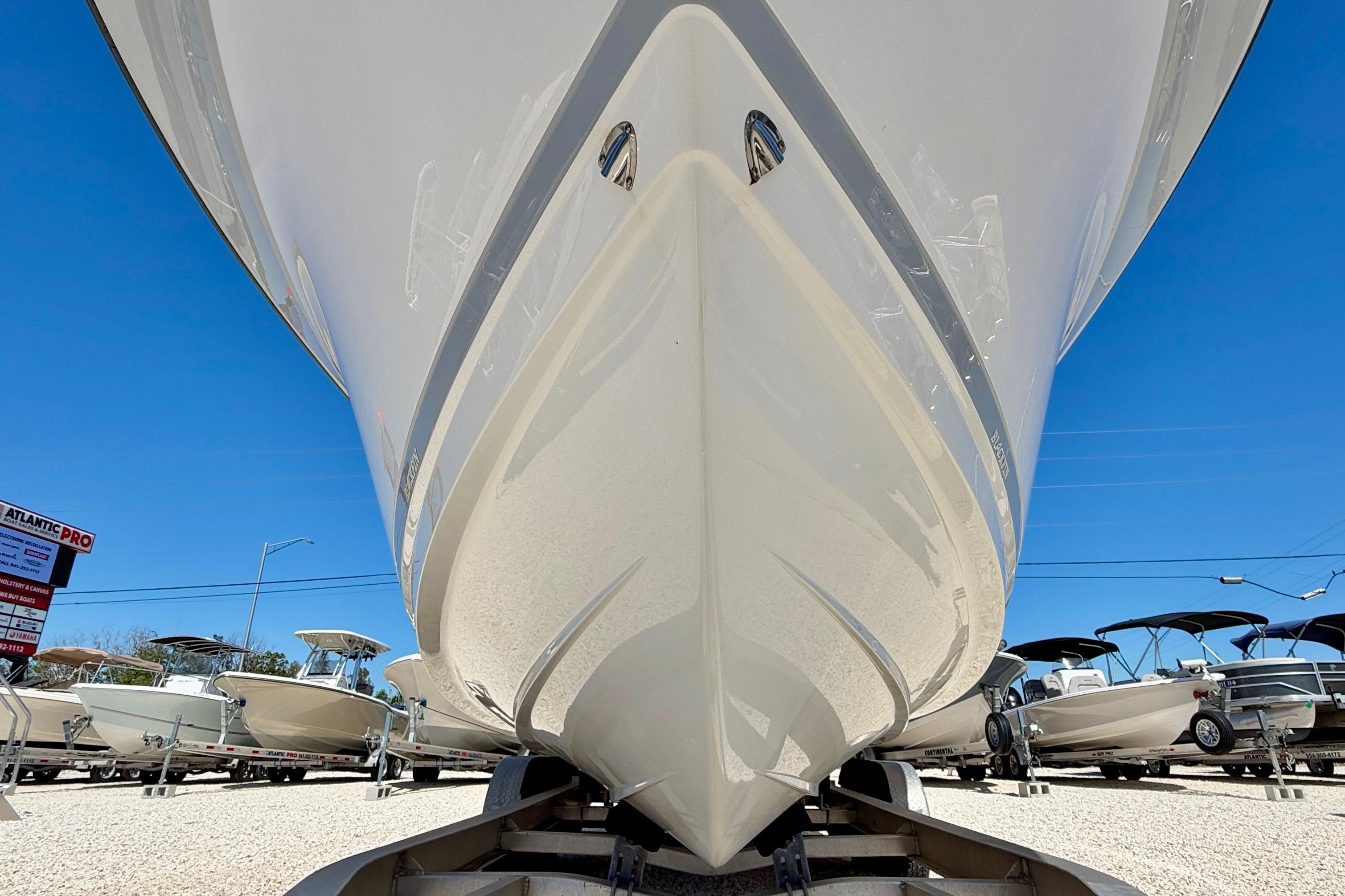 2023 Blackfin 272 DC boat on trailer, viewed from below, with clear blue sky.