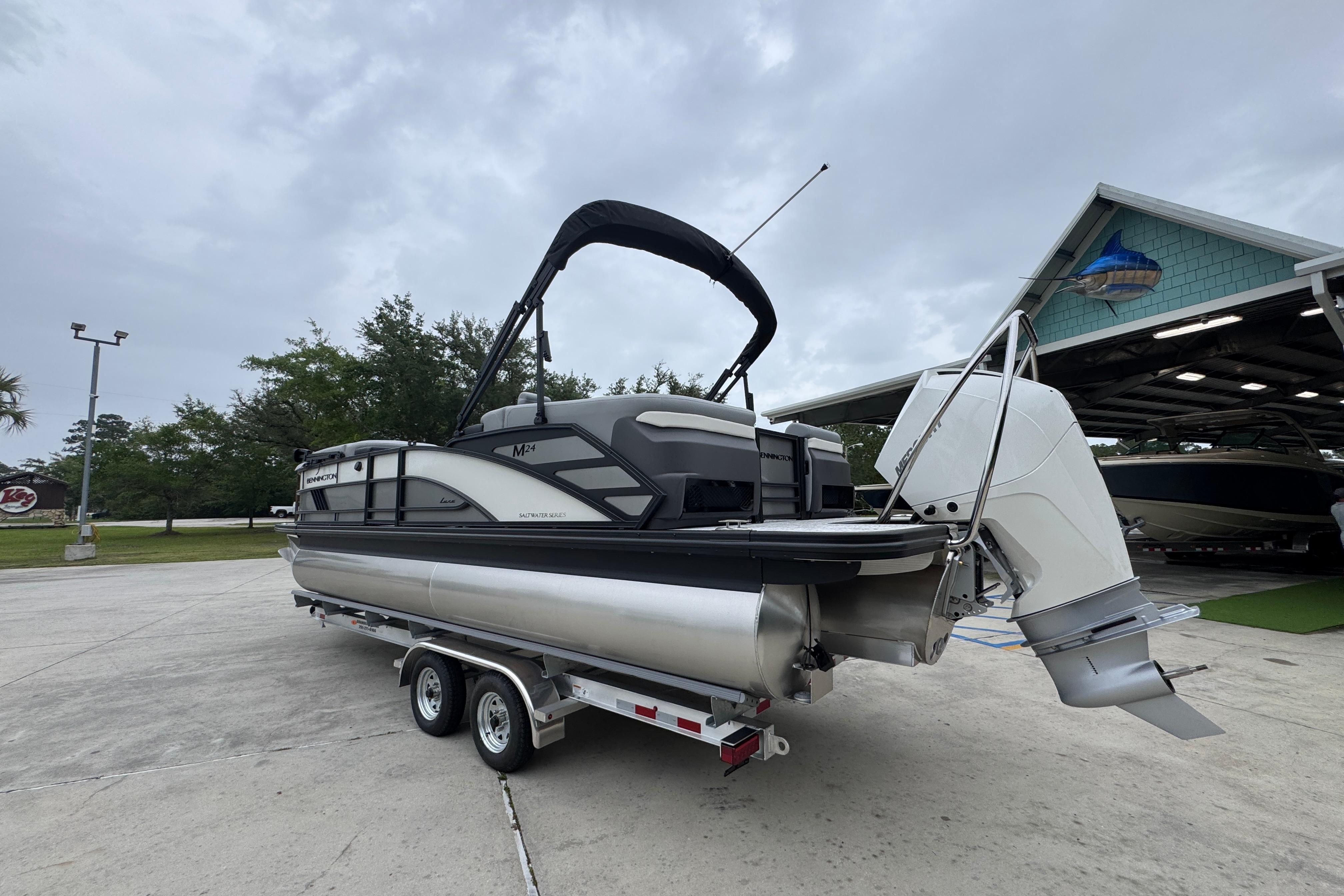 2027 Bennington 24 MFB pontoon boat on trailer, parked outdoors.