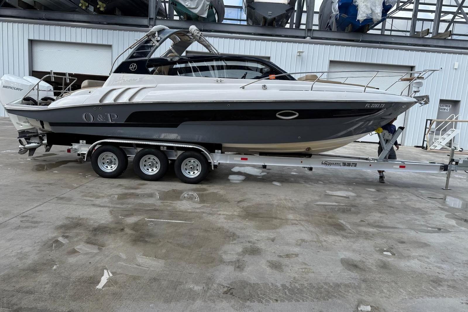 2024 Hanover 305 boat on trailer, parked in industrial area.