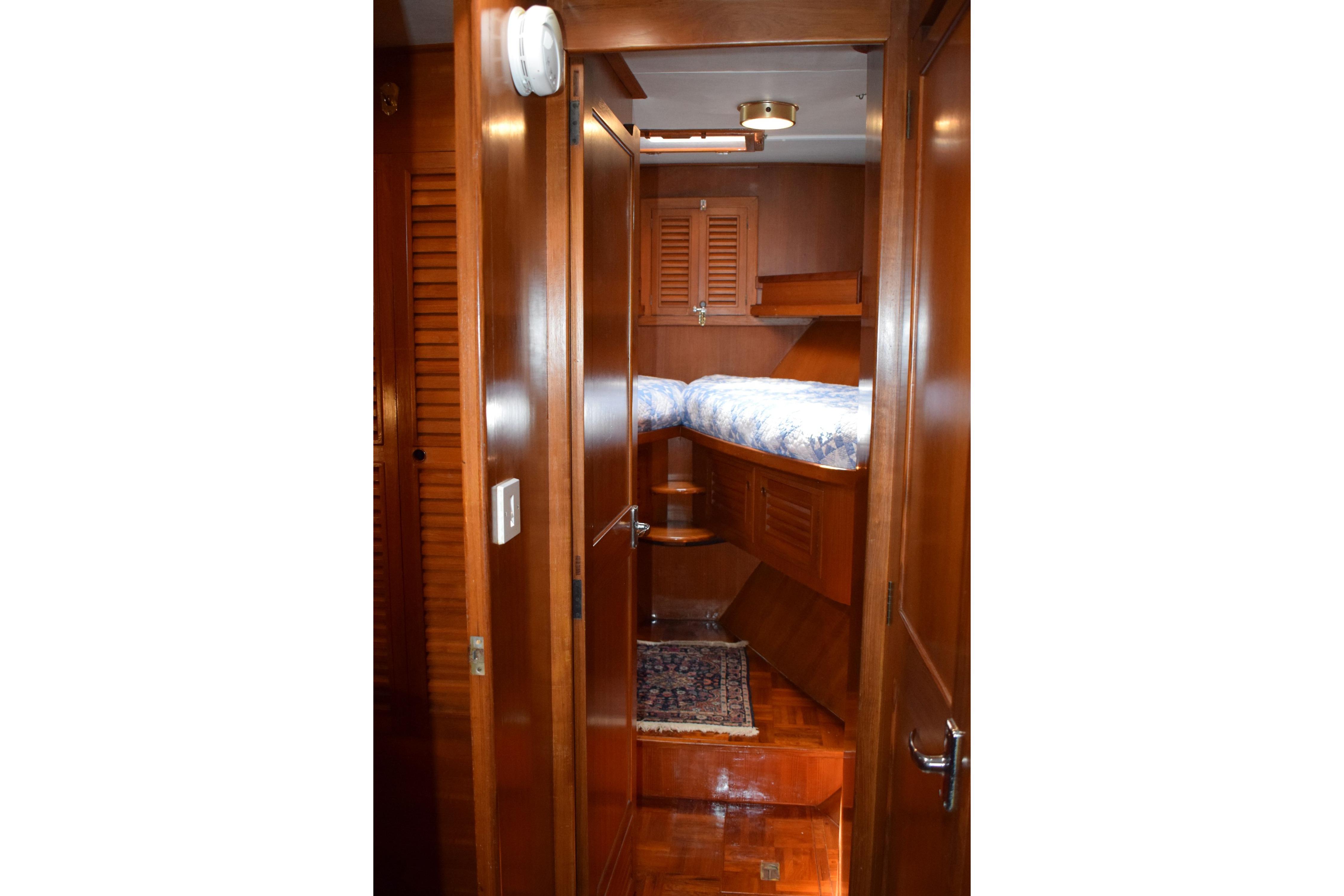 Cozy wooden cabin interior of 1980 Cheoy Lee 52 Motorsailer with bed and rug.