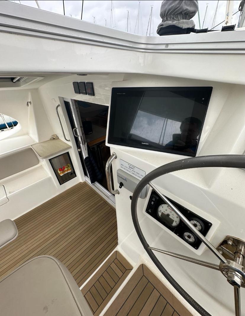 2018 Knysna 500 SE yacht cockpit with steering wheel, navigation screen, and wooden flooring.