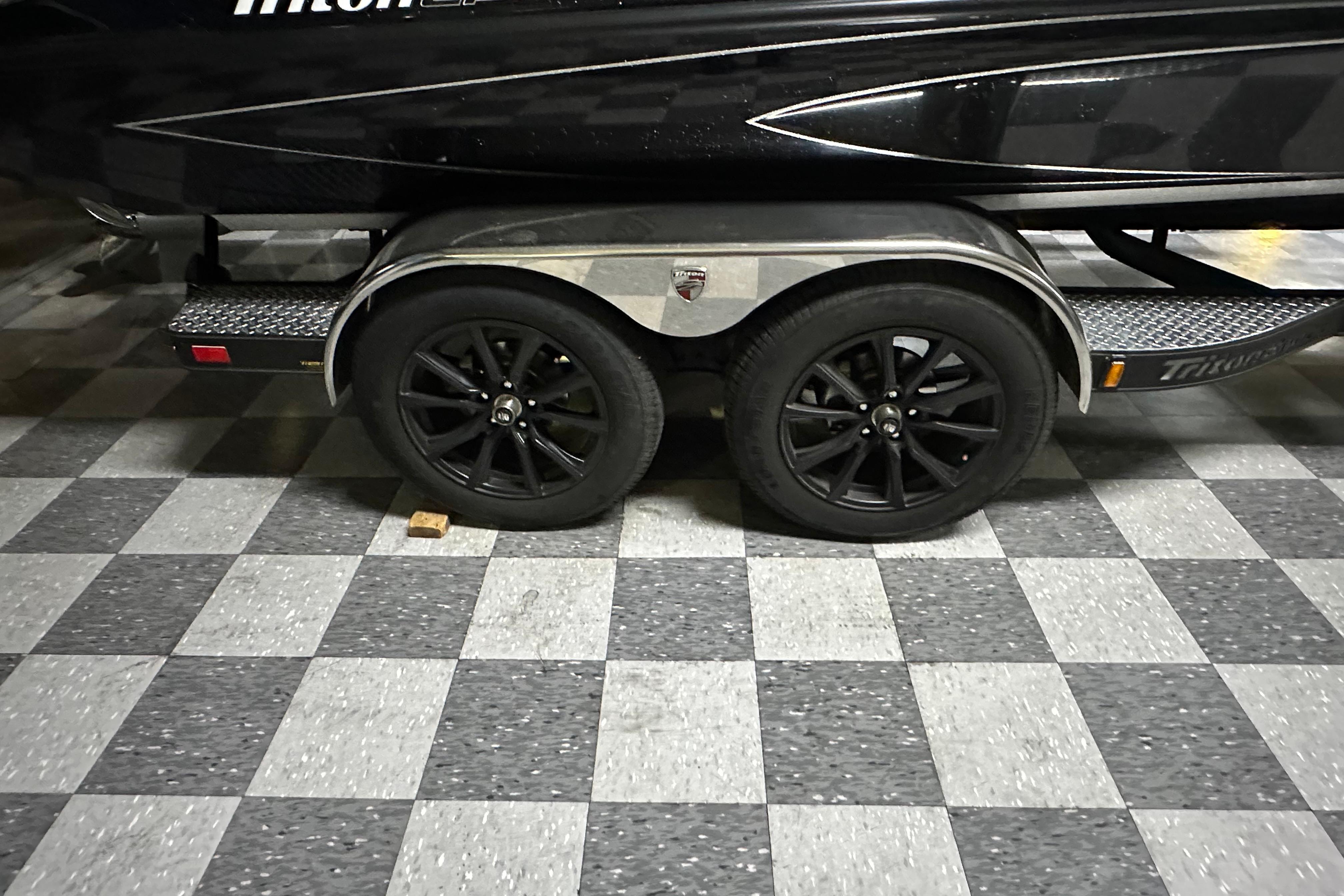 2025 Triton 21XP Patriot trailer with black wheels on checkered floor.