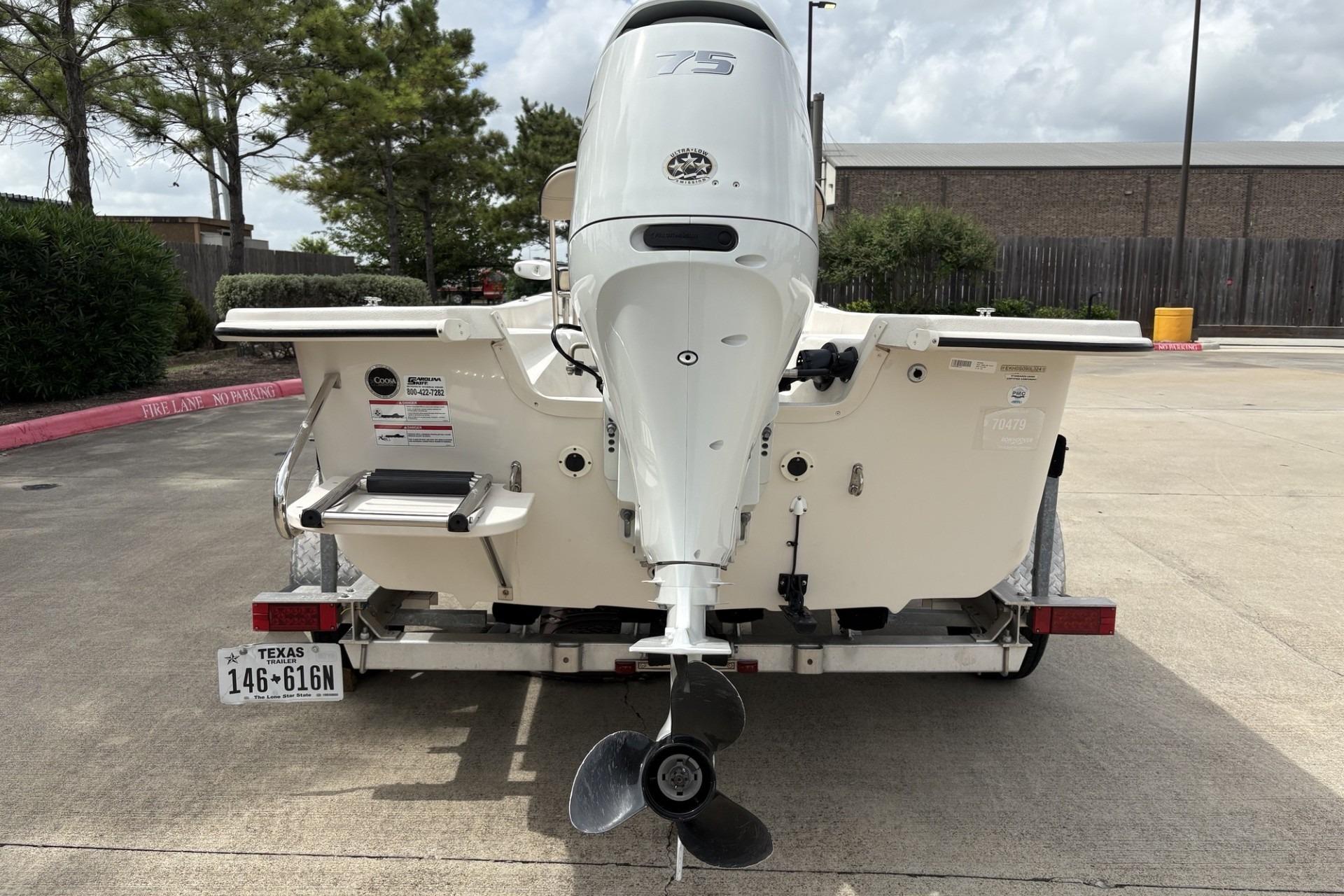 2024 Carolina Skiff E18 JVX CC boat rear view with outboard motor on trailer.