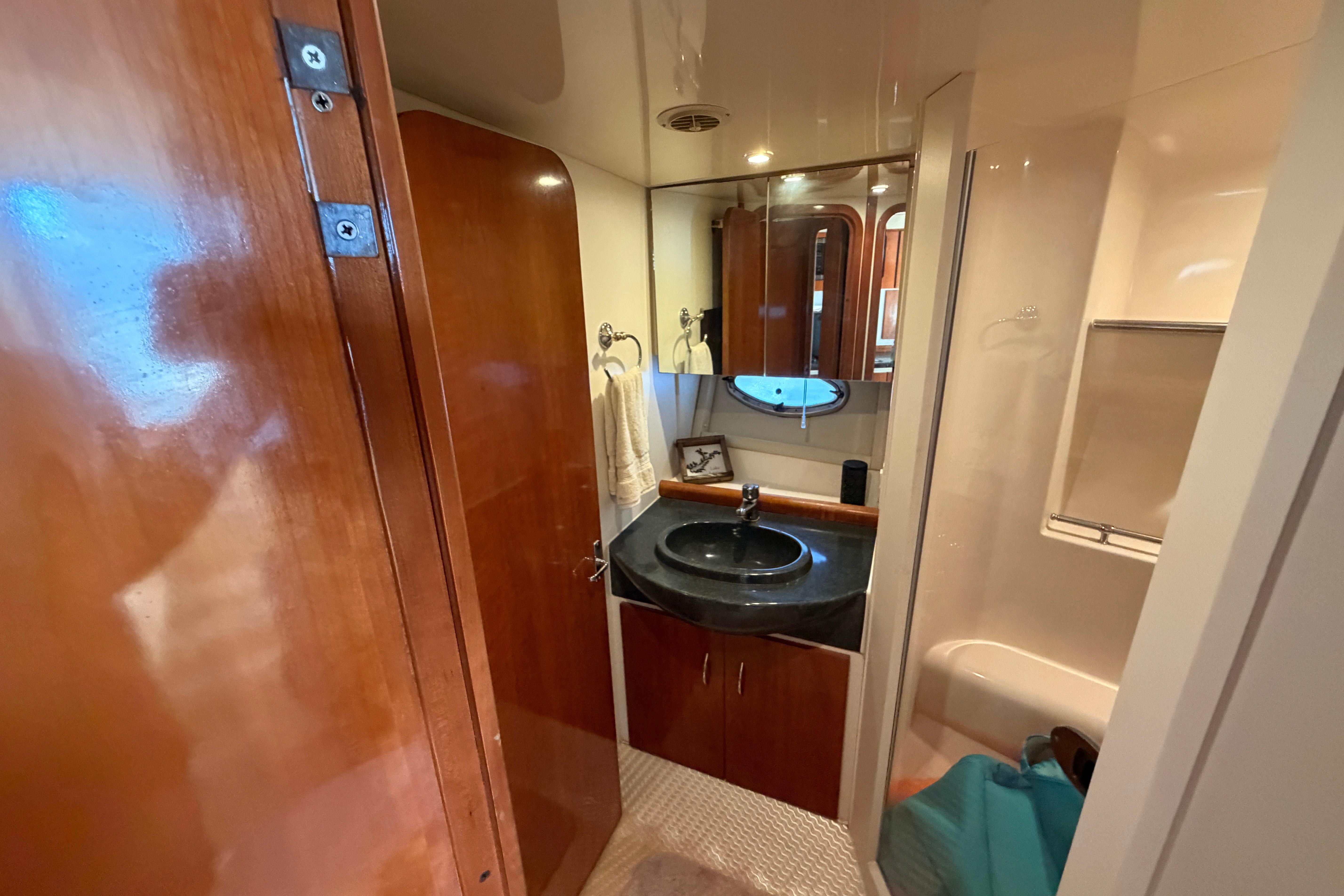 Bathroom interior of 2003 Carver 350 Mariner yacht with wood accents and modern fixtures.