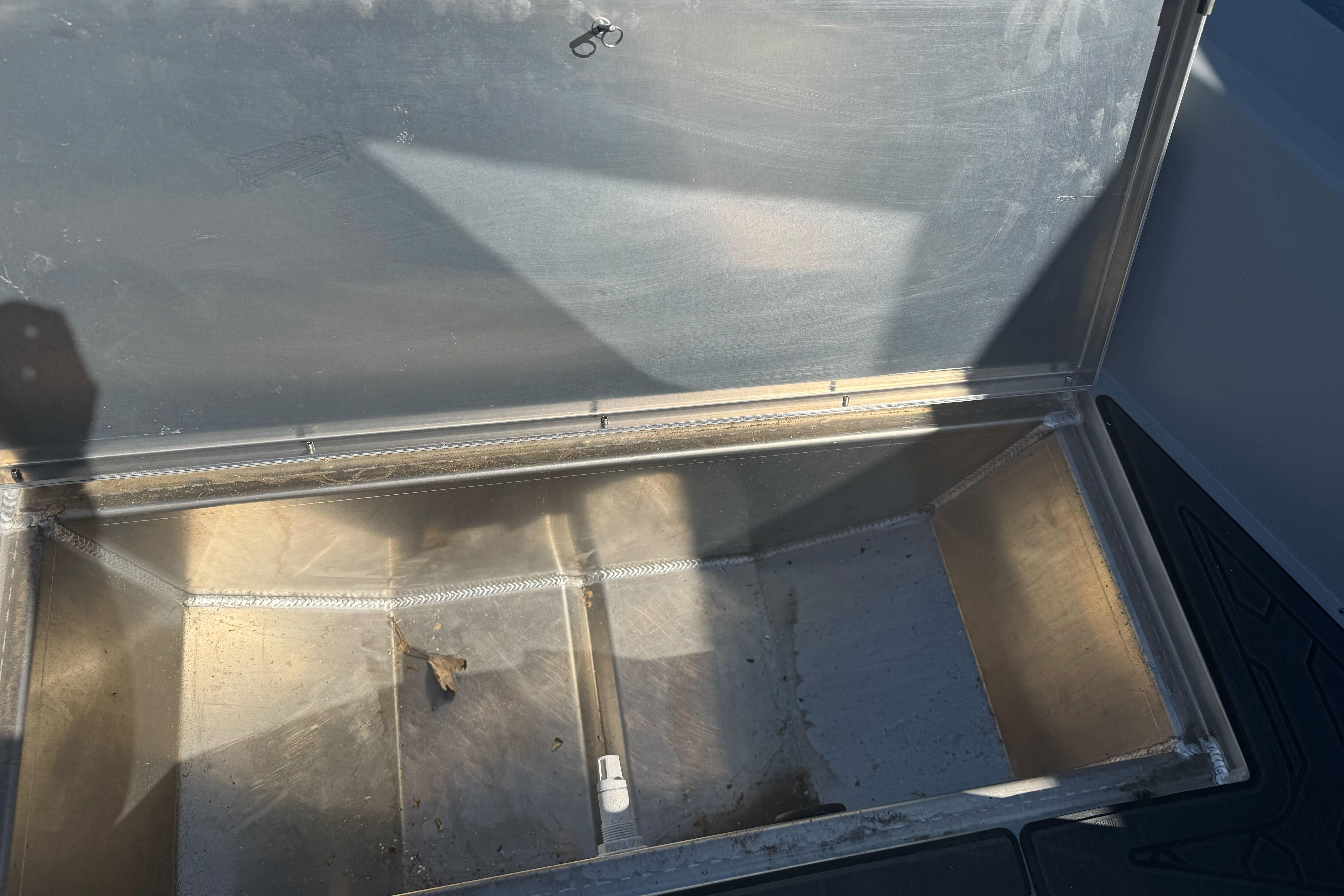 Open storage compartment in a 2026 KingFisher 16 Falcon boat, showing interior details.