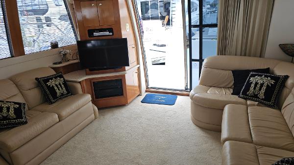 Luxurious interior of 2000 Carver 450 Voyager Pilothouse with beige leather seating and TV.