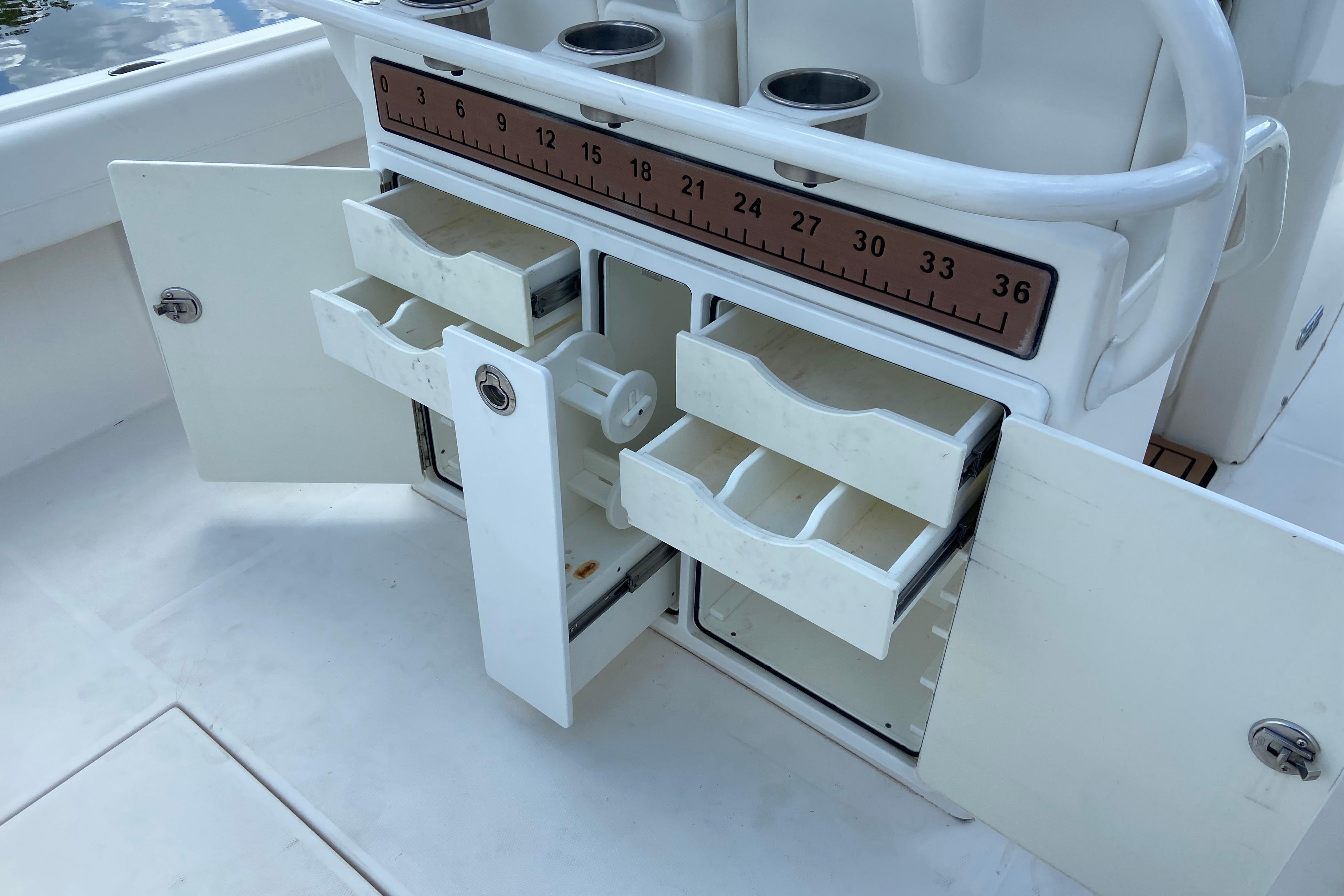 2021 Regulator 28 boat storage compartments with open drawers and measuring ruler.