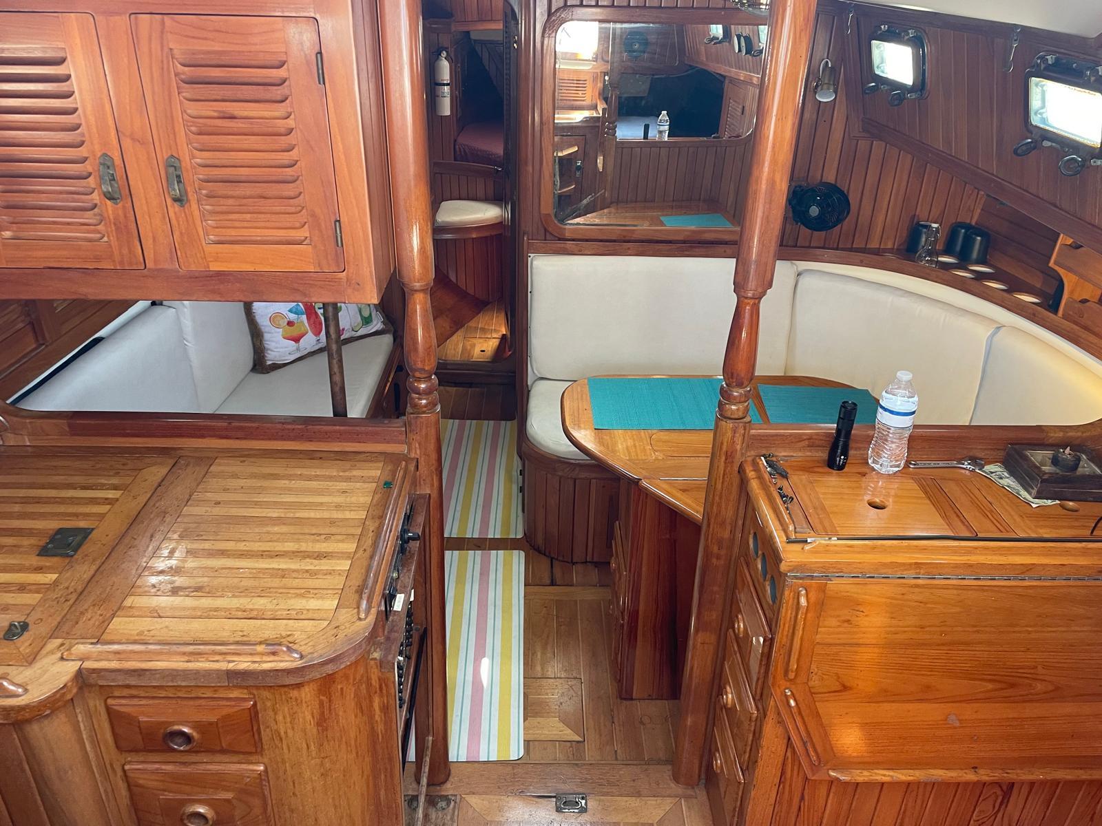 1986 Cabo Rico CB38 yacht interior with wooden cabinetry and cozy seating area.