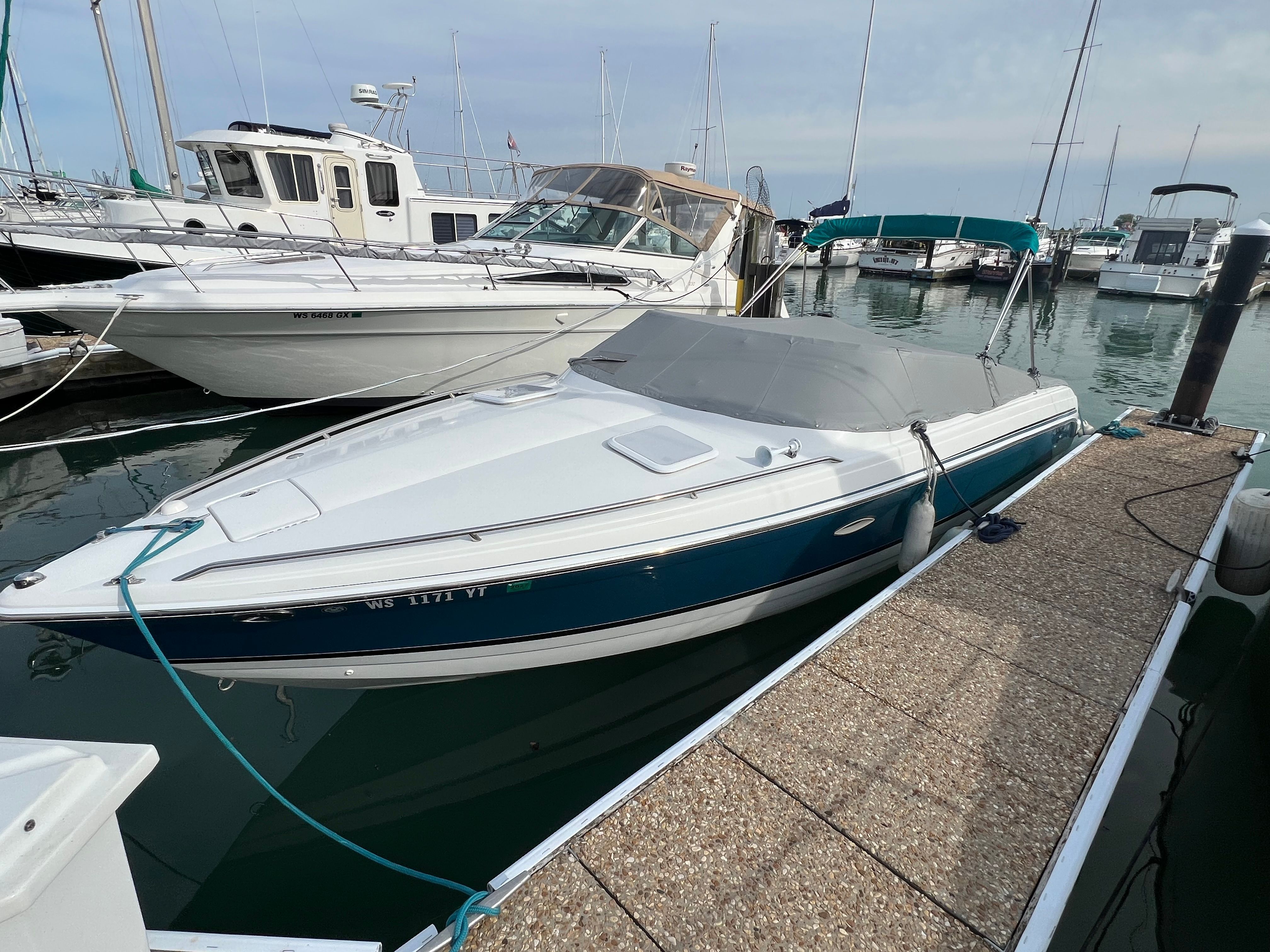 A 2005 Formula 260 Sun Sport docked at a marina, surrounded by other boats.