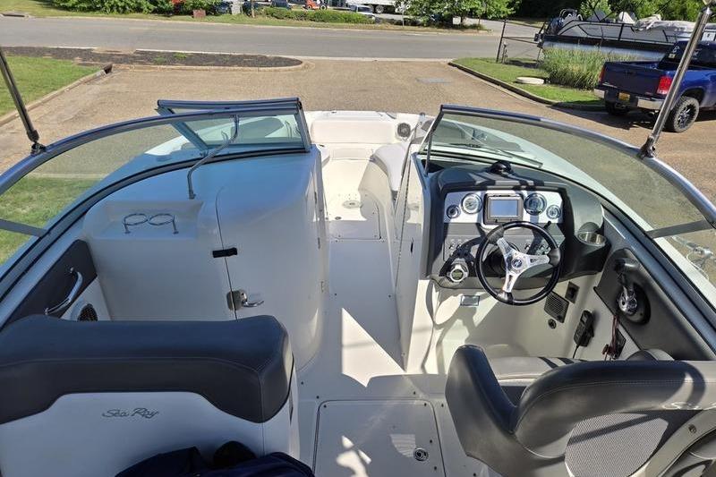 2011 Sea Ray 300 Sundeck interior with steering wheel and seating, parked outdoors.