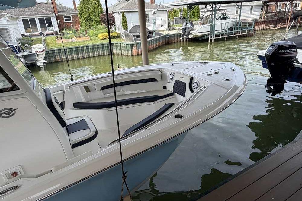 2024 Tidewater 232 LXF boat docked in a serene waterfront setting.