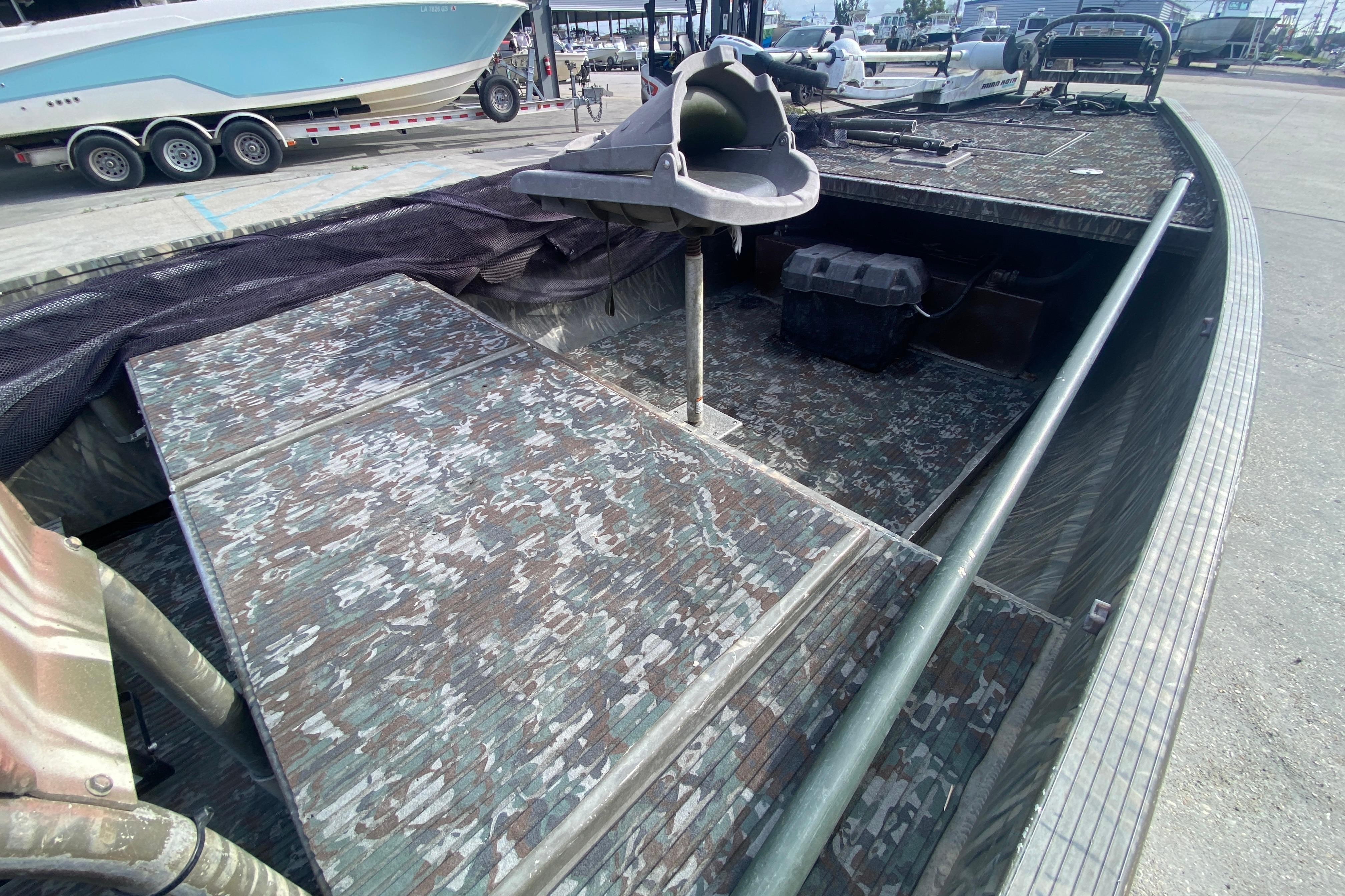 2009 Gator Trax MUD BUDDY boat with camouflage interior, docked at marina.
