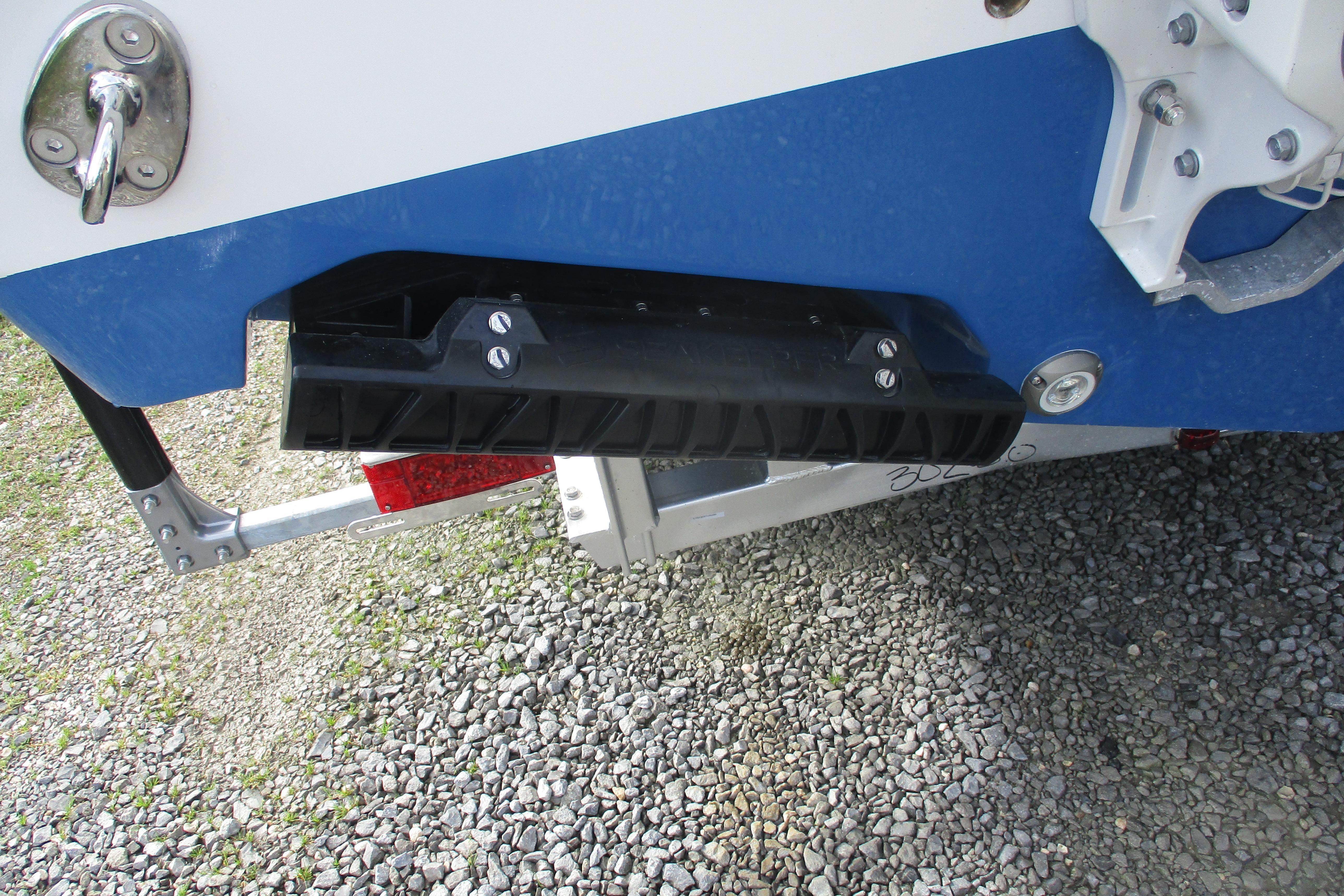 2026 Sportsman Open 302 Center Console boat trailer detail on gravel surface.