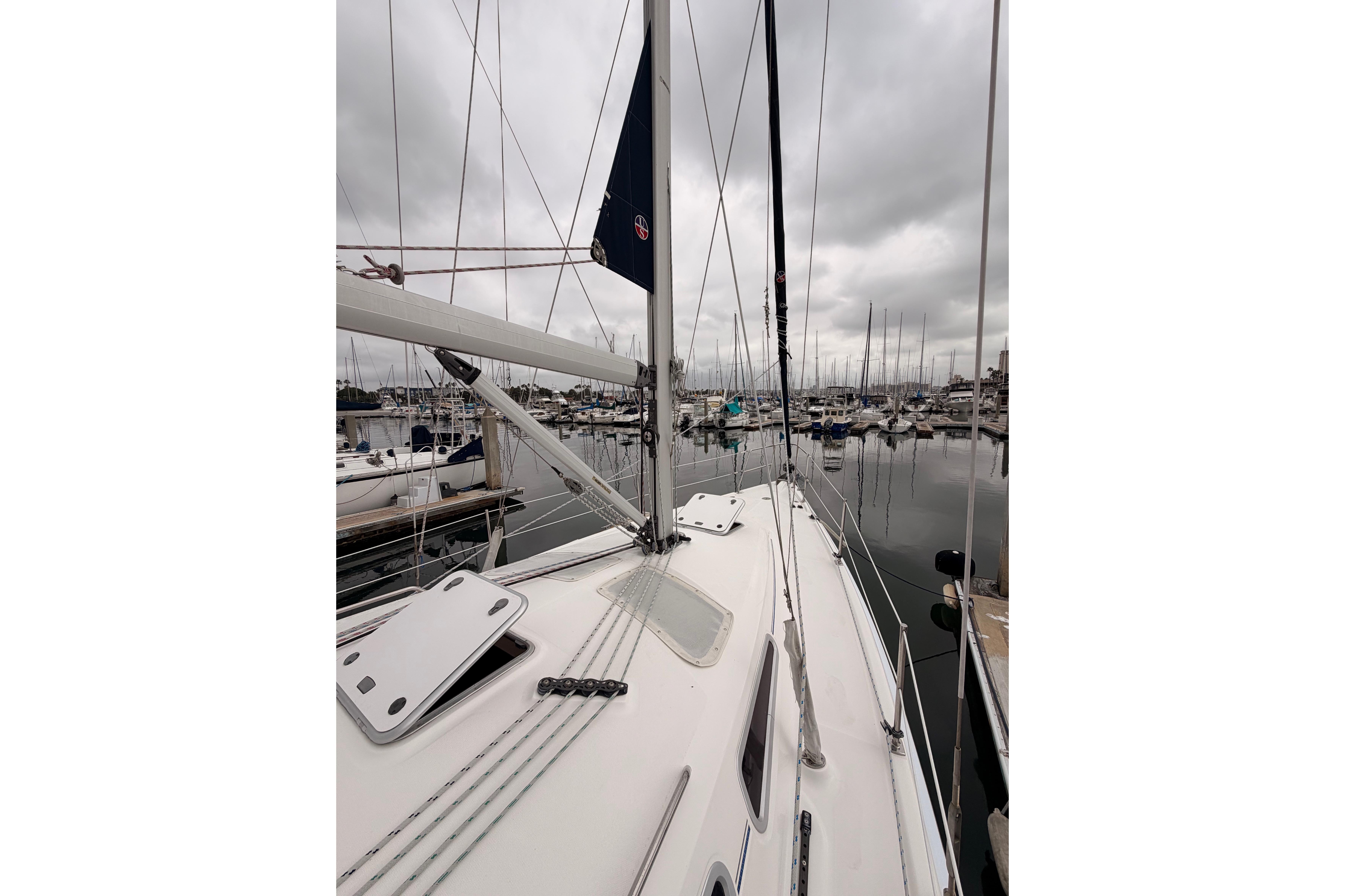 2009 Hunter 38 sailboat docked in a marina under overcast skies.