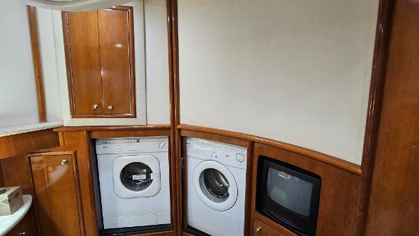 Laundry area in 2000 Carver 450 Voyager Pilothouse with washer, dryer, and TV.