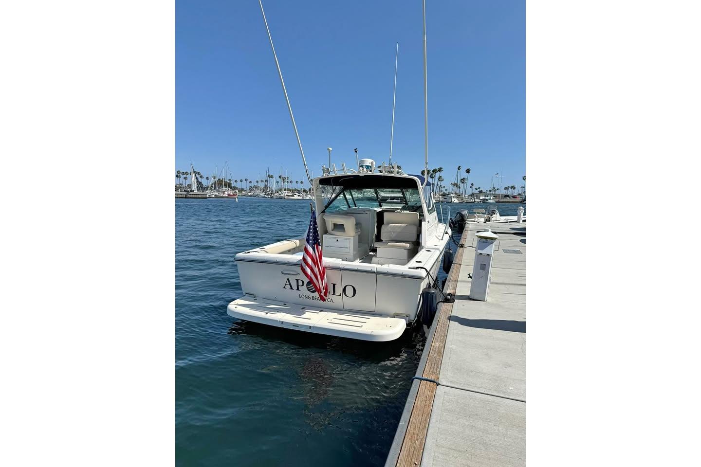 1995 Tiara Yachts 2900 Open docked, displaying American flag, clear blue sky.