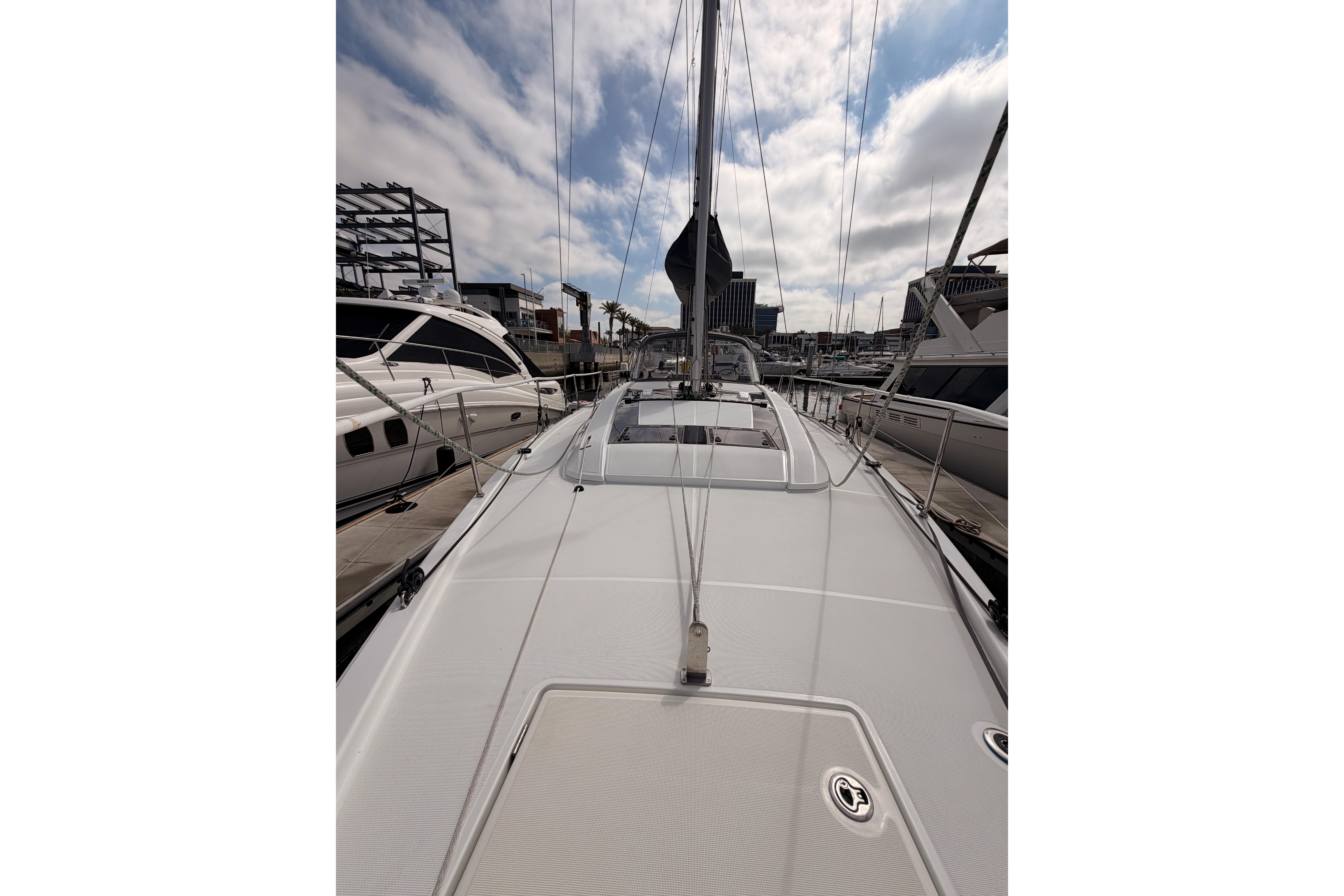 2020 Beneteau Oceanis 46.1 sailboat docked at marina under cloudy sky.