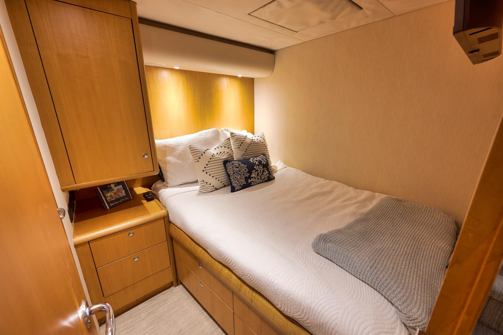 Cozy bedroom in 2003 Weaver Custom Sportfish yacht with wooden cabinetry and soft lighting.