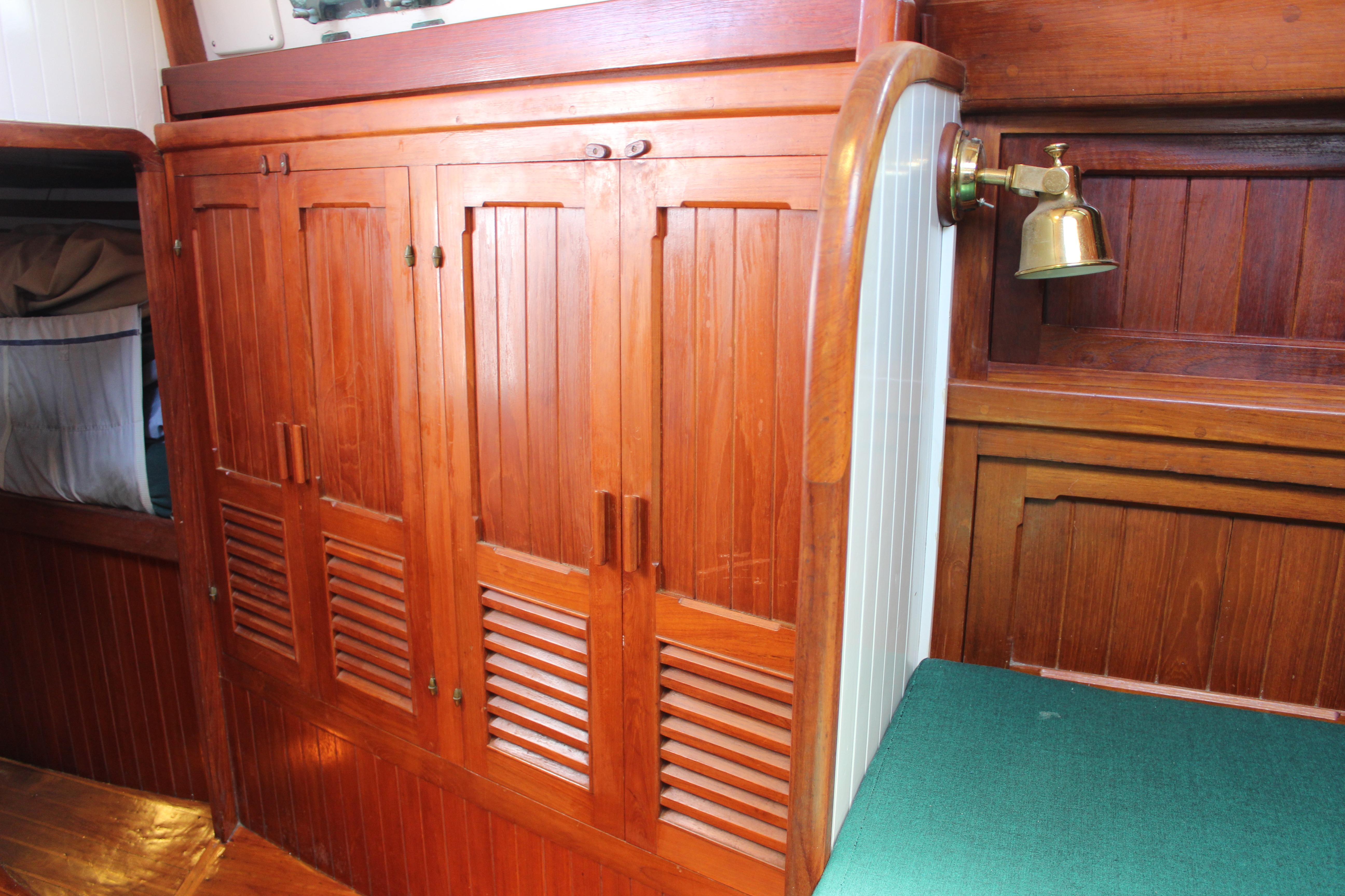 Wooden interior of 1981 Kelly Peterson 46 yacht with cabinets and brass lamp.