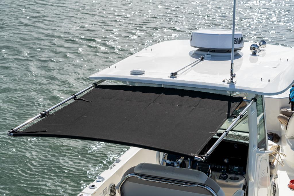 2024 Boston Whaler 280 Dauntless boat with extended sunshade on water.