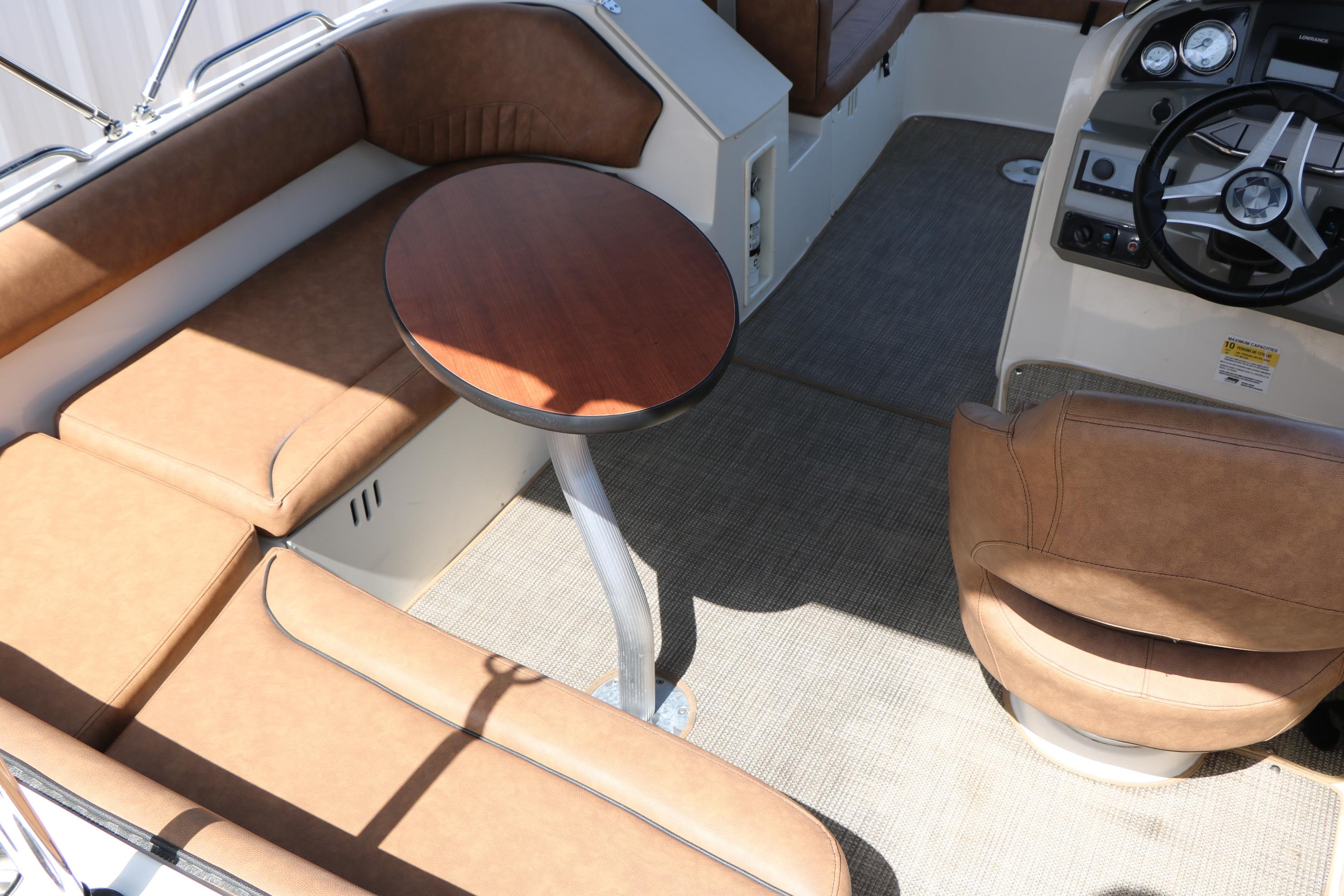 2022 Stingray 192 SC boat interior with tan seating, round table, and steering console.