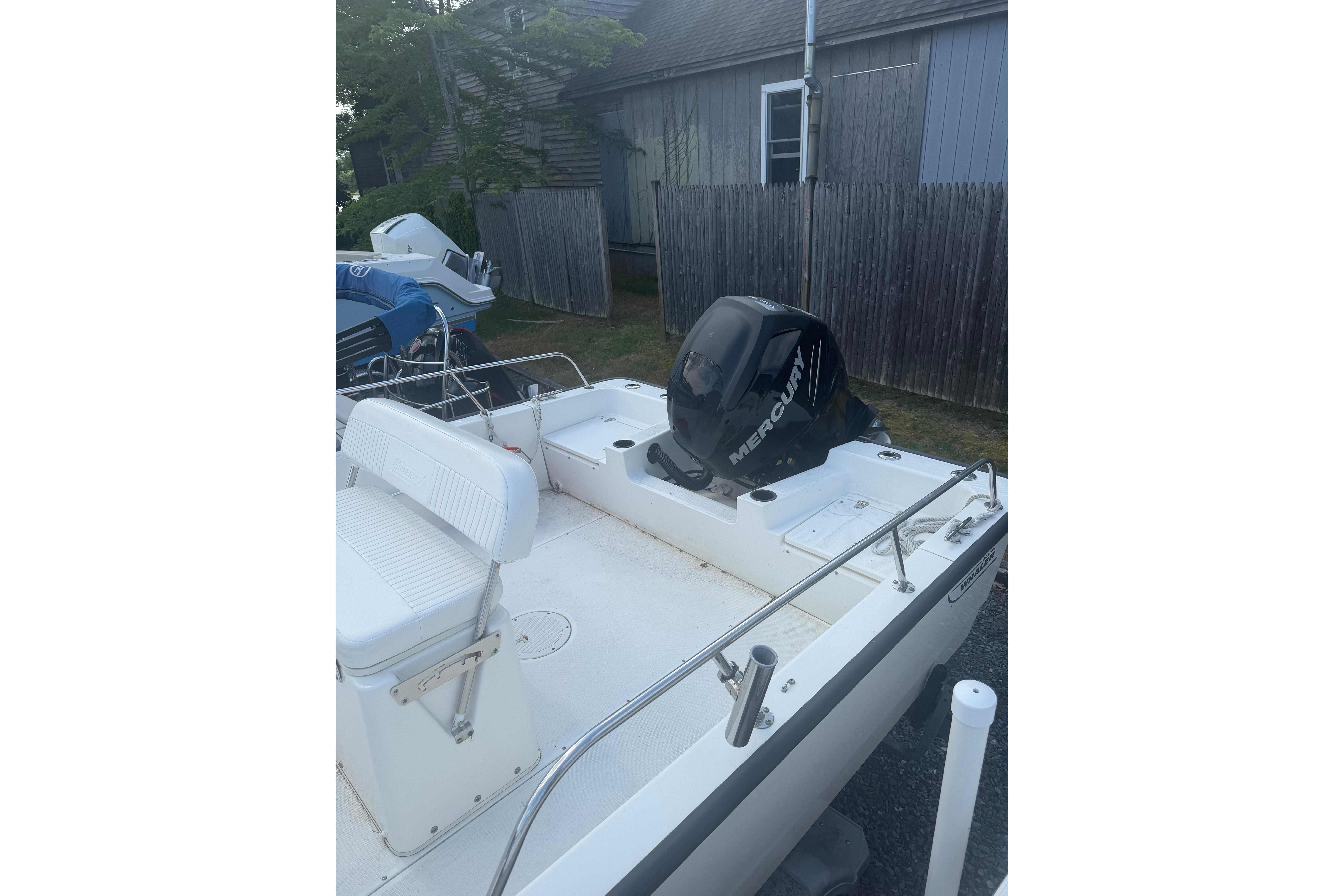 2015 Boston Whaler 210 Montauk boat with Mercury engine, parked outdoors.