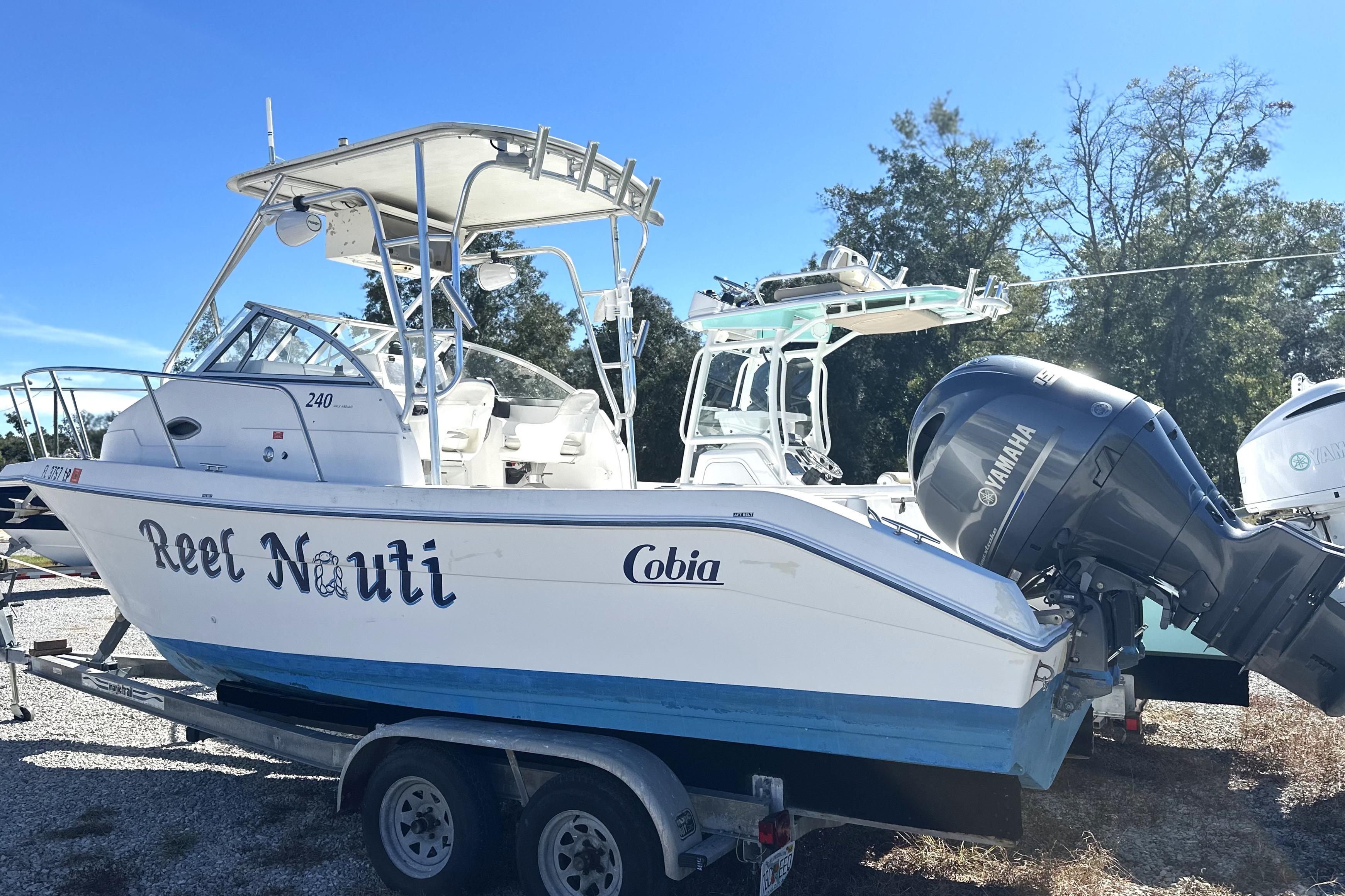 2000 Cobia 240 Walkaround boat on trailer with Yamaha outboard motor, named "Reel Nauti."