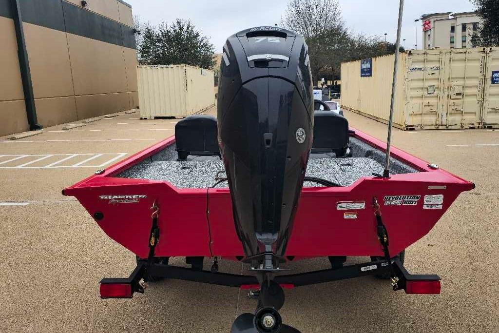 2026 Tracker Pro Team 175 Crappie Edition boat, red, rear view in parking lot.