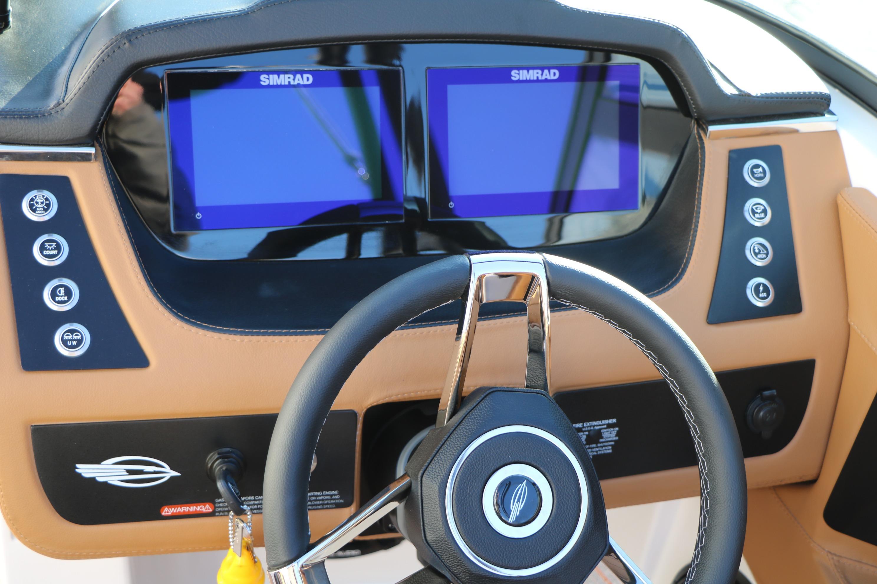 Steering wheel and dashboard of 2026 Chaparral 247 SSX boat with Simrad displays.