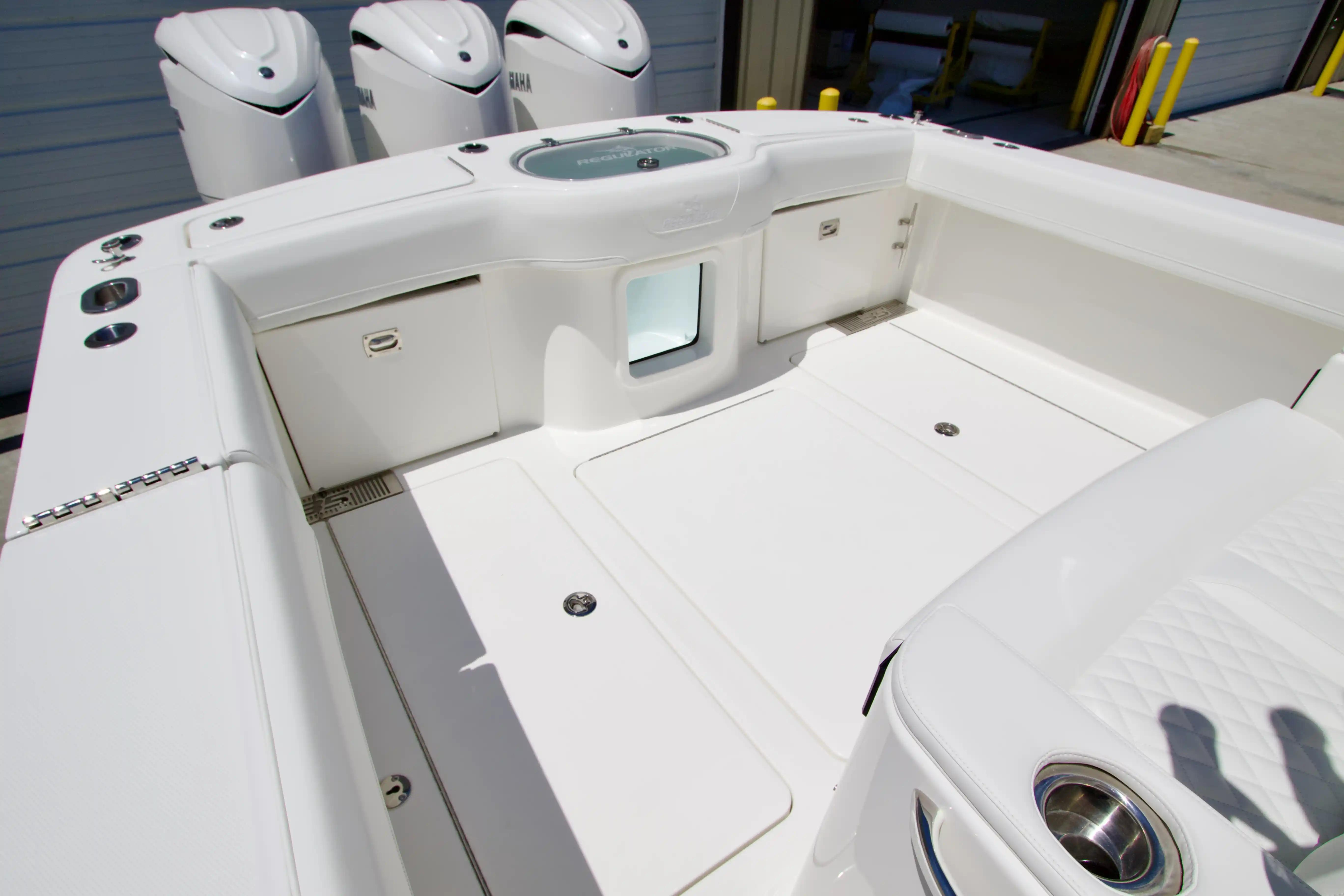 2027 Regulator 35 boat deck with storage compartments and triple Yamaha engines.