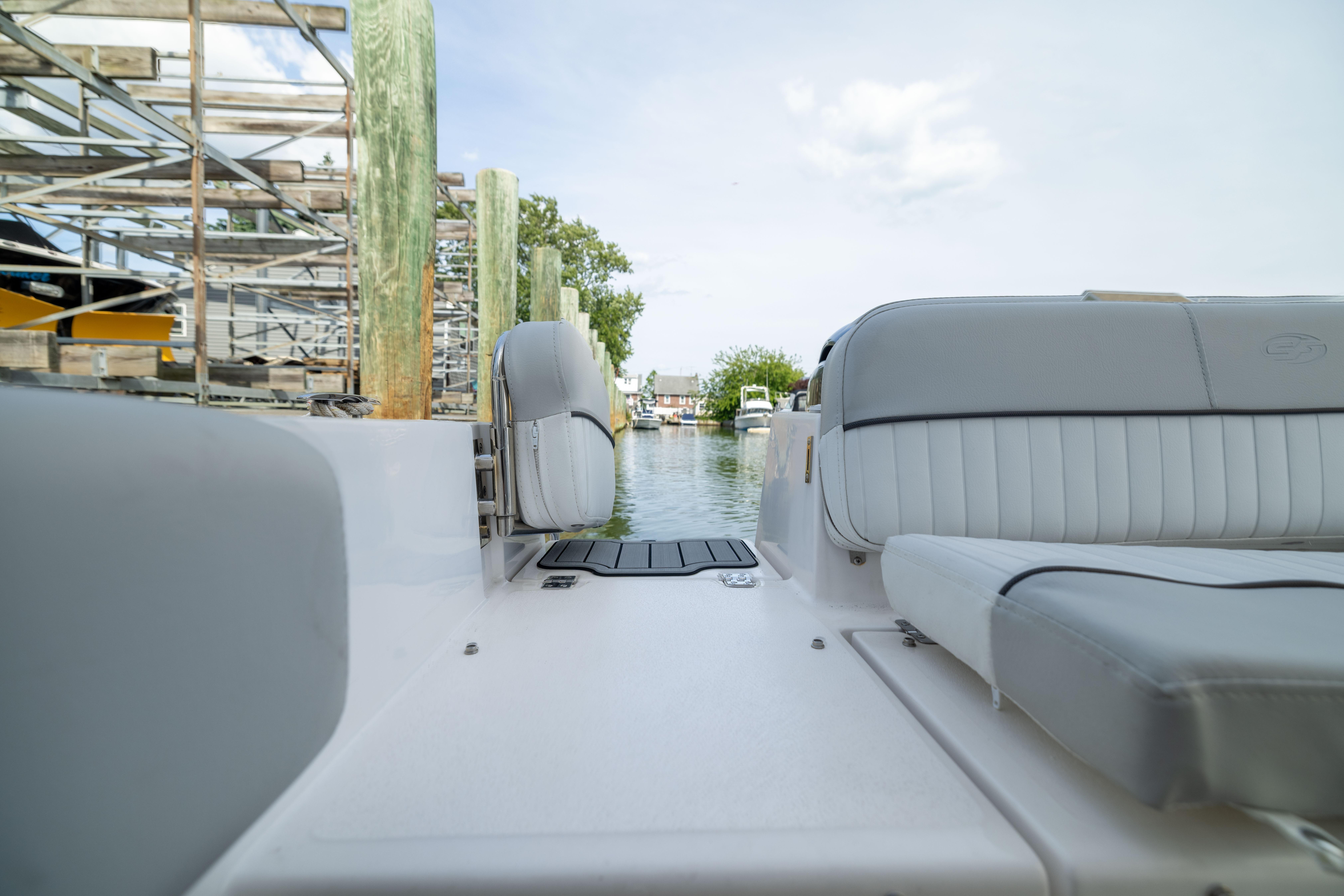2023 Sea Fox 228 Commander boat interior with cushioned seating, dockside view.