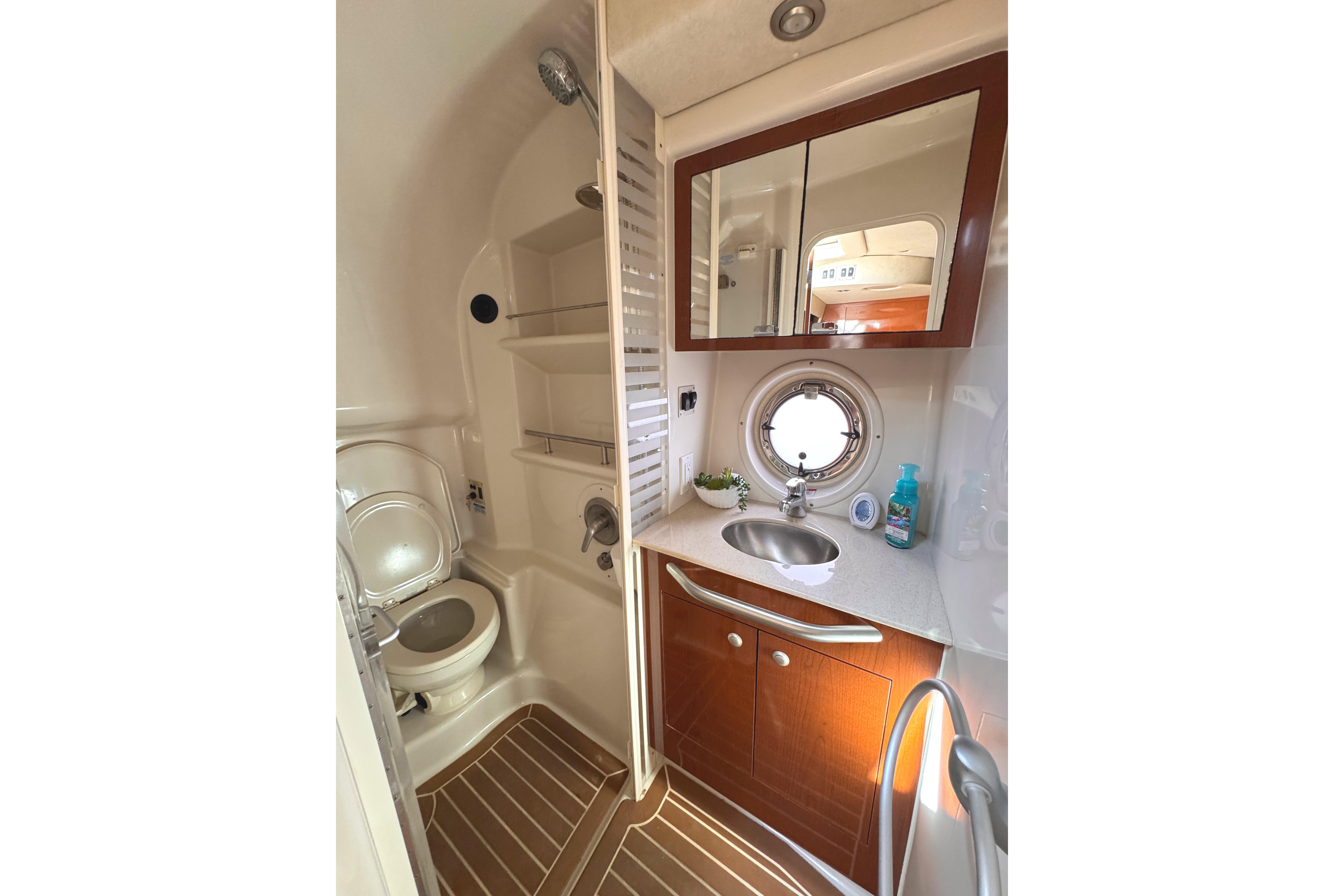 Luxurious bathroom in 2008 Sea Ray Sundancer 350 yacht with modern fixtures and porthole window.