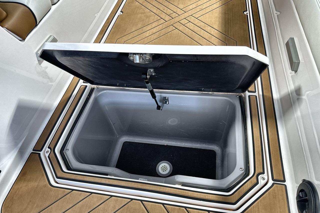 Open storage compartment on 2020 Supra SE boat with wooden flooring.