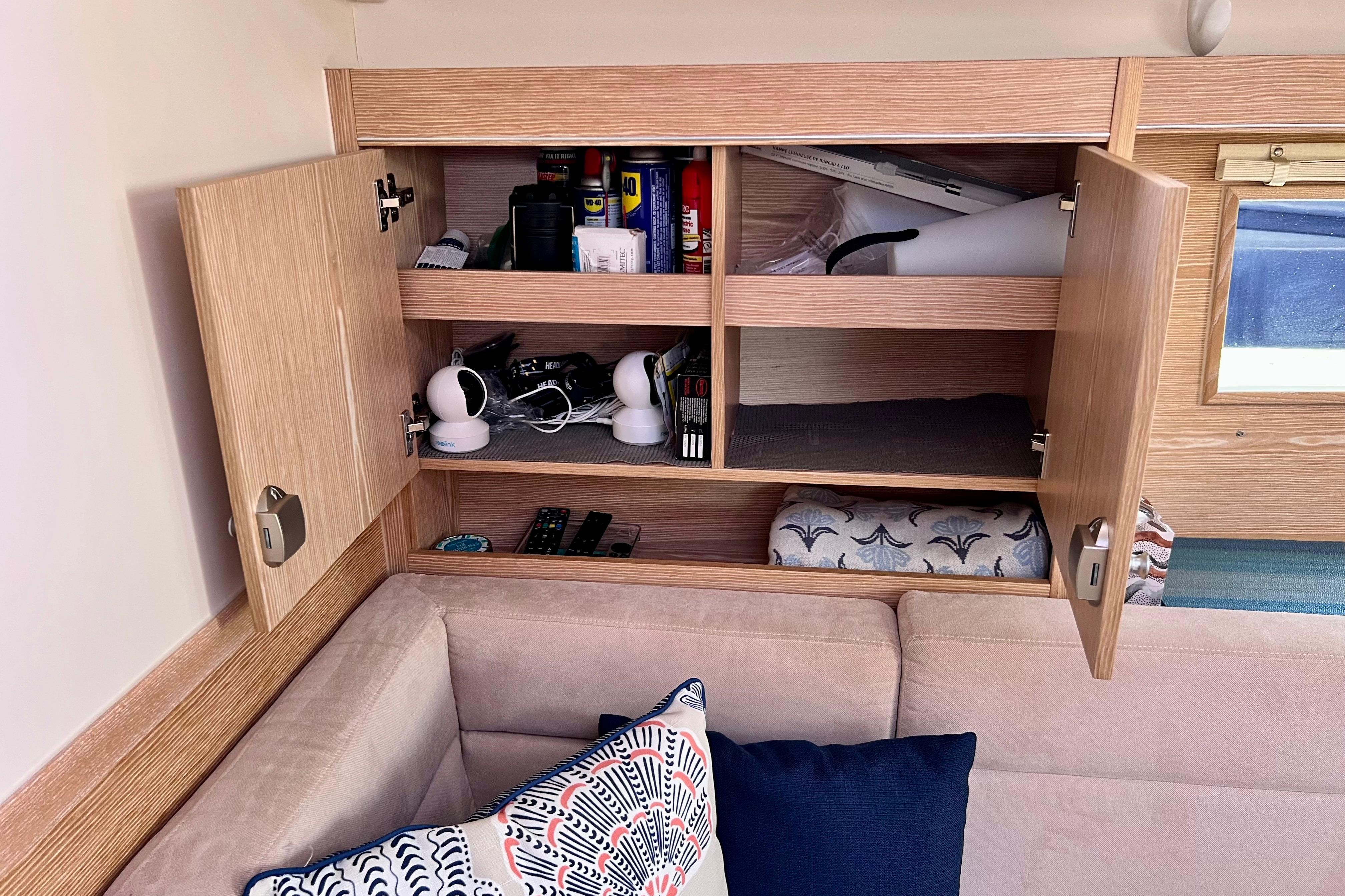 Interior of 2016 Hanse 455 yacht with open wooden cabinets and cozy seating area.