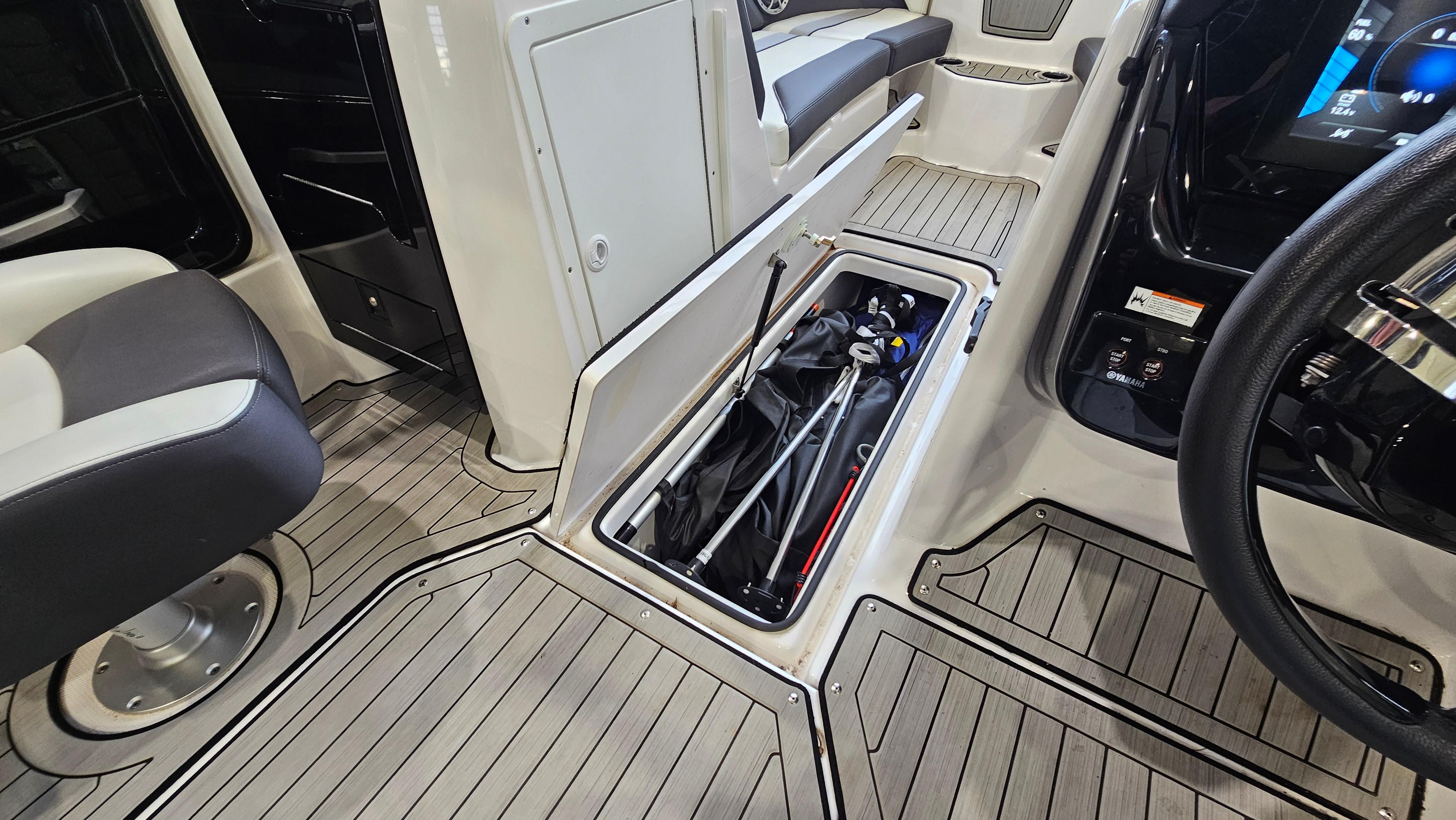 2021 Yamaha Boats 212SD interior with open storage compartment and seating.