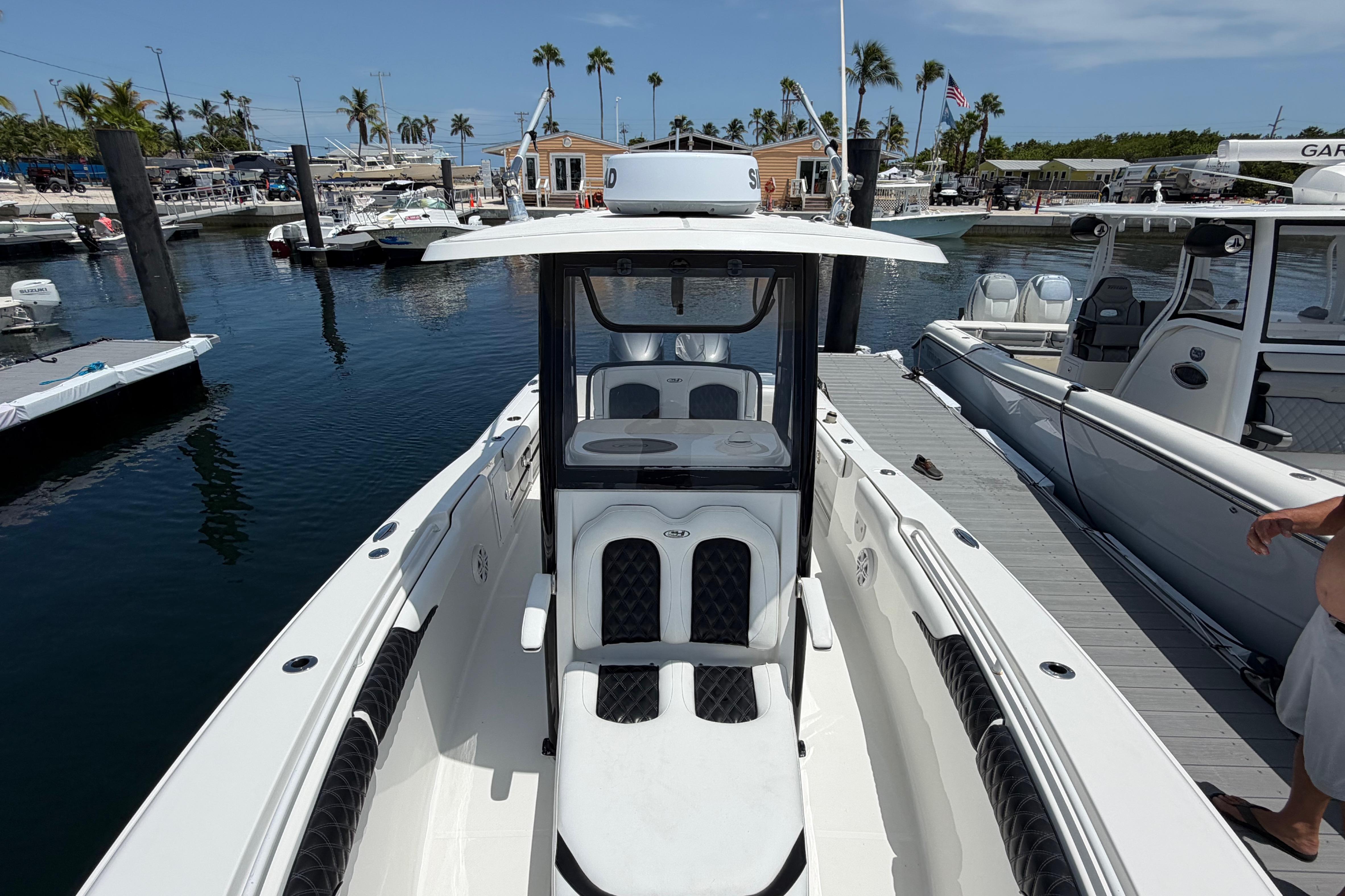 2019 Sea Hunt Gamefish 27 Coffin Box boat docked at marina with palm trees.