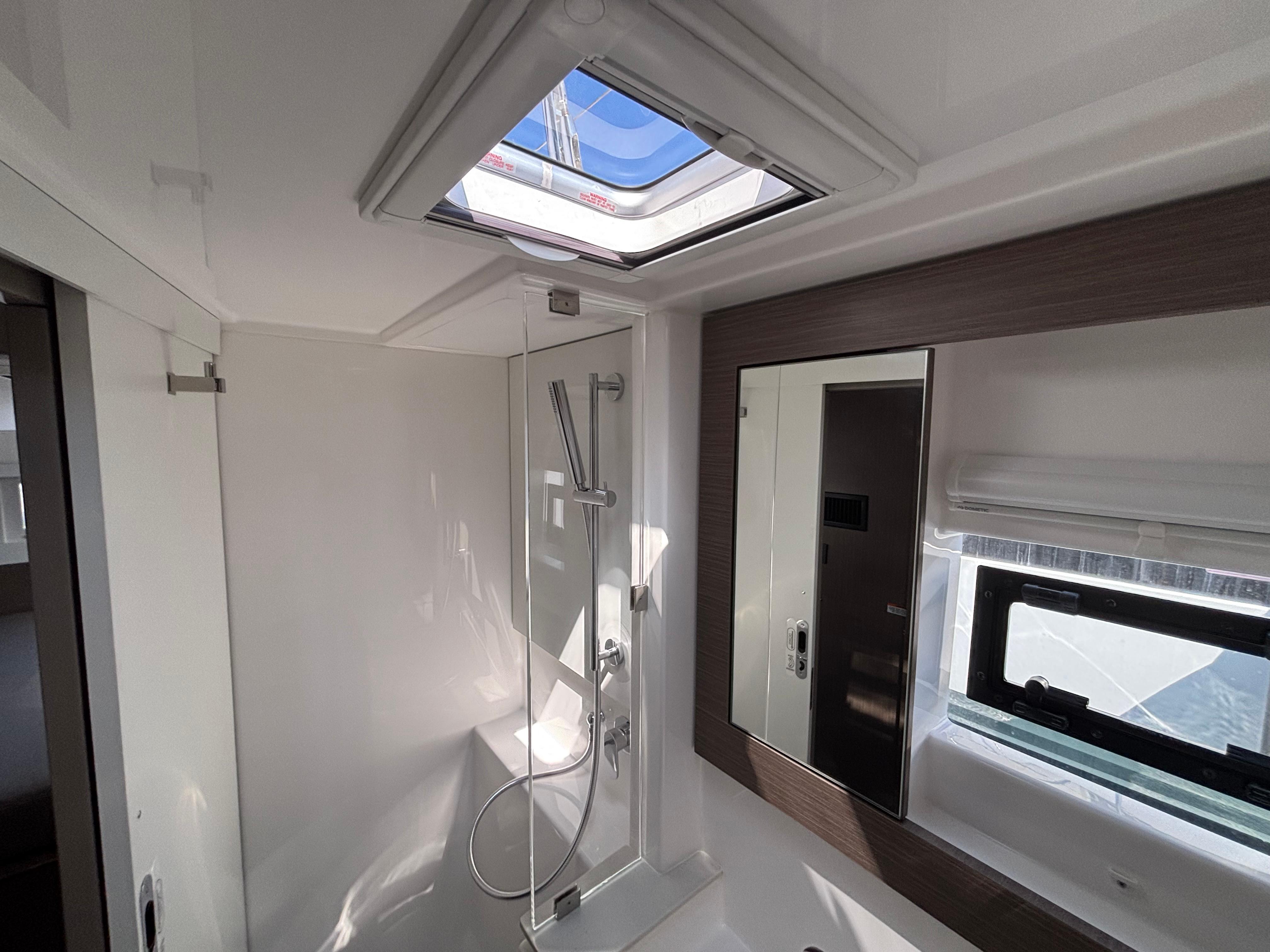 Modern bathroom interior in 2025 Leopard 42 yacht, featuring skylight and sleek shower design.