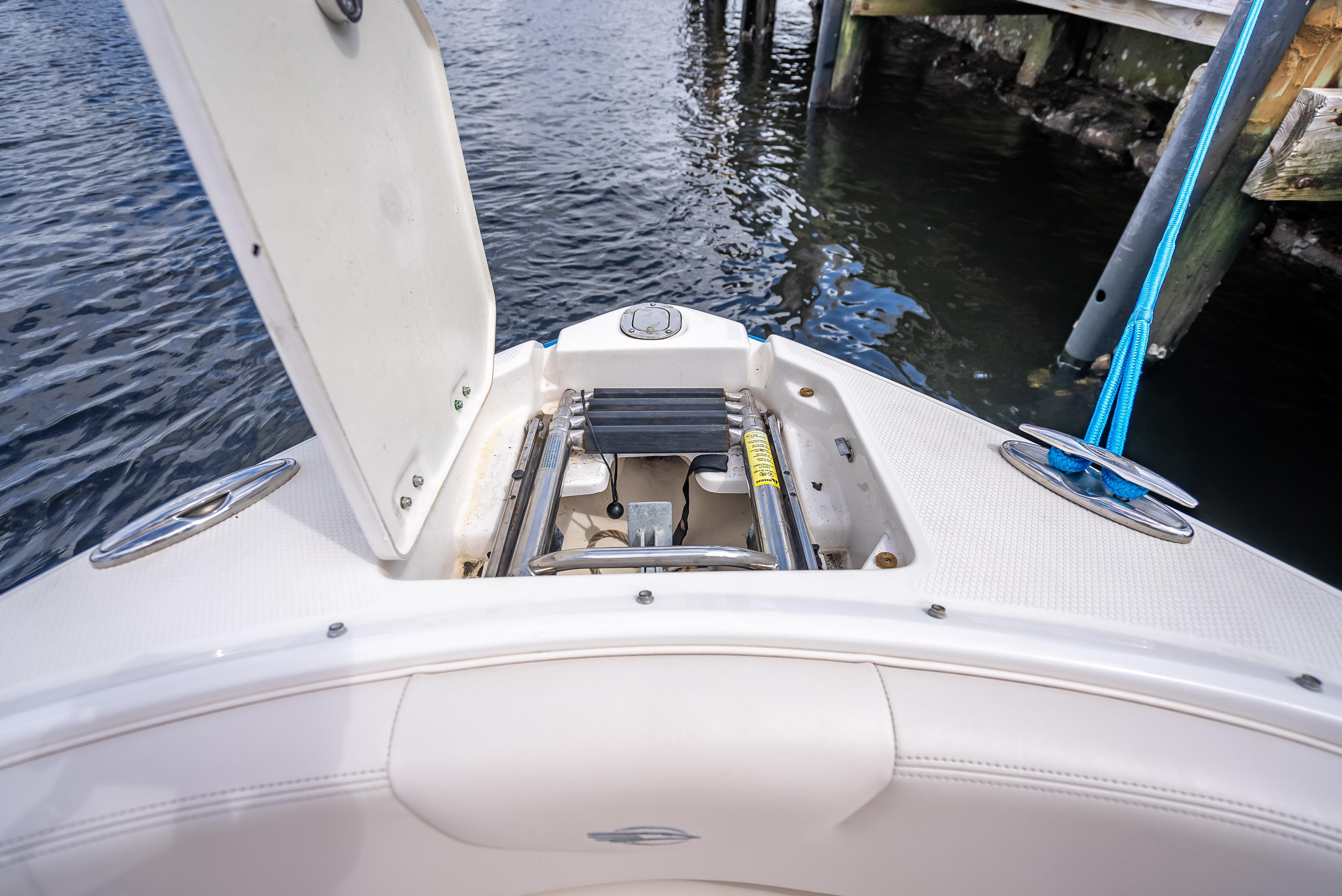 2017 Chaparral 227 SSX boat with open anchor storage compartment by the water.