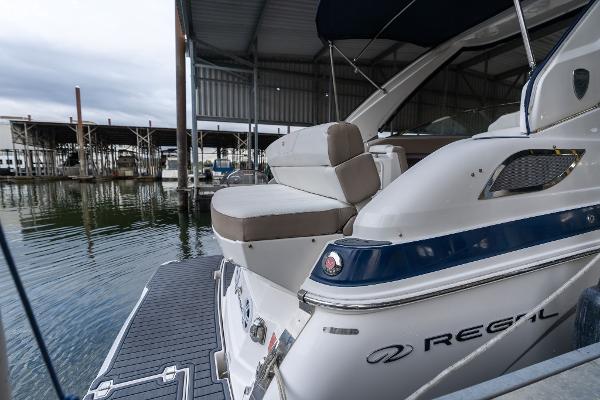 2016 Regal 28 Express boat docked in a marina, showcasing sleek design and comfortable seating.