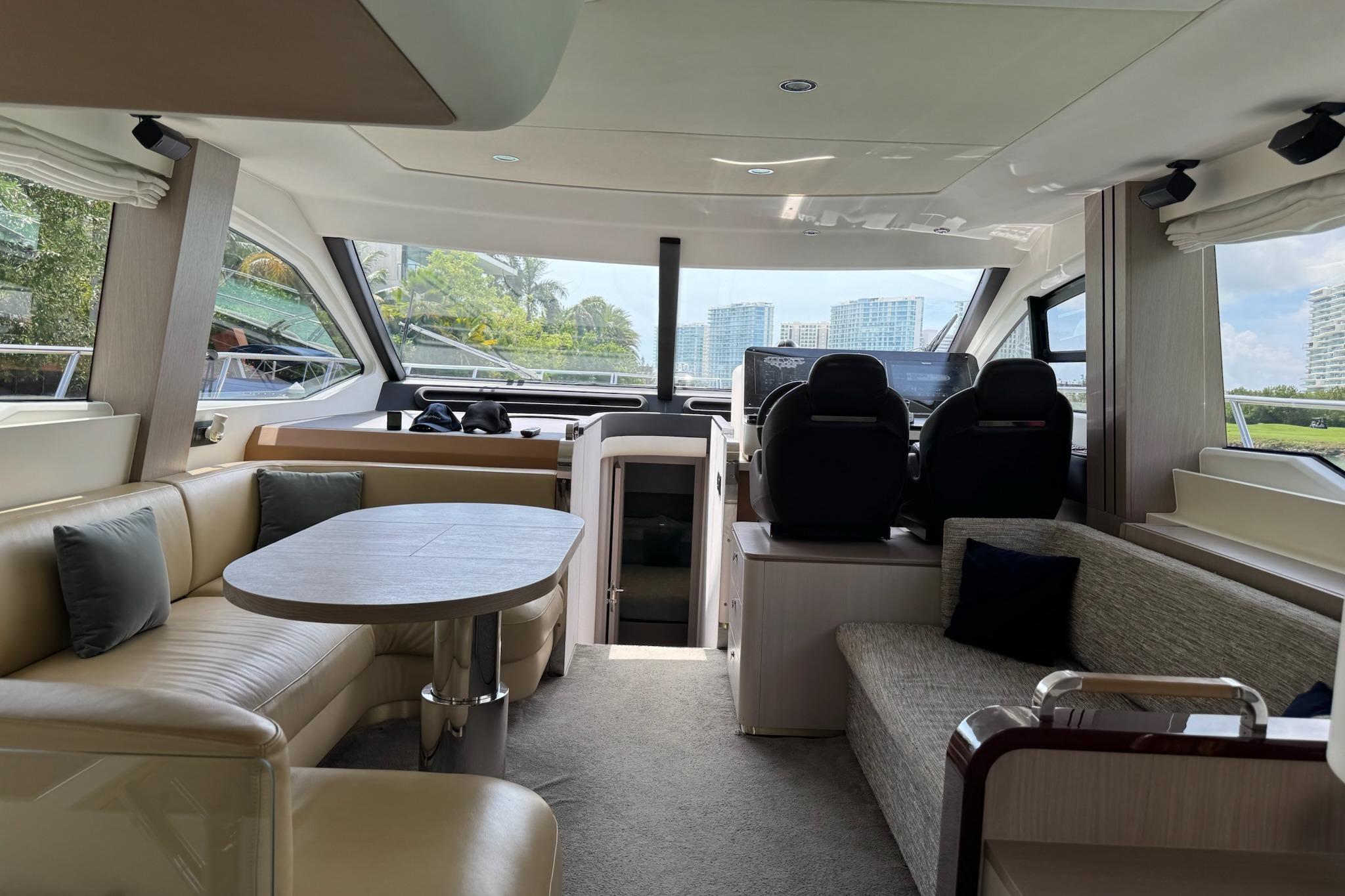 Luxurious interior of 2021 Azimut 55 yacht with modern seating and panoramic windows.