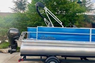 2026 Sun Tracker Party Barge 18 DLX pontoon boat on trailer, parked outdoors.