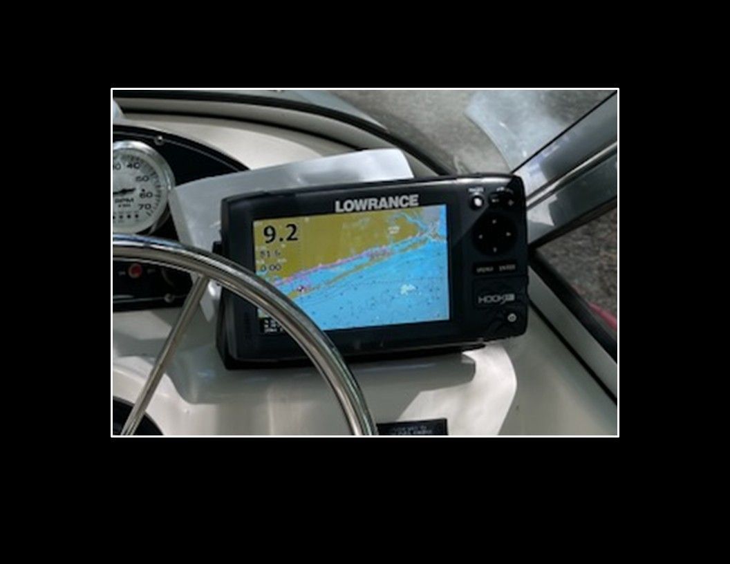 A Lowrance navigation system on a boat displays a map and speed.