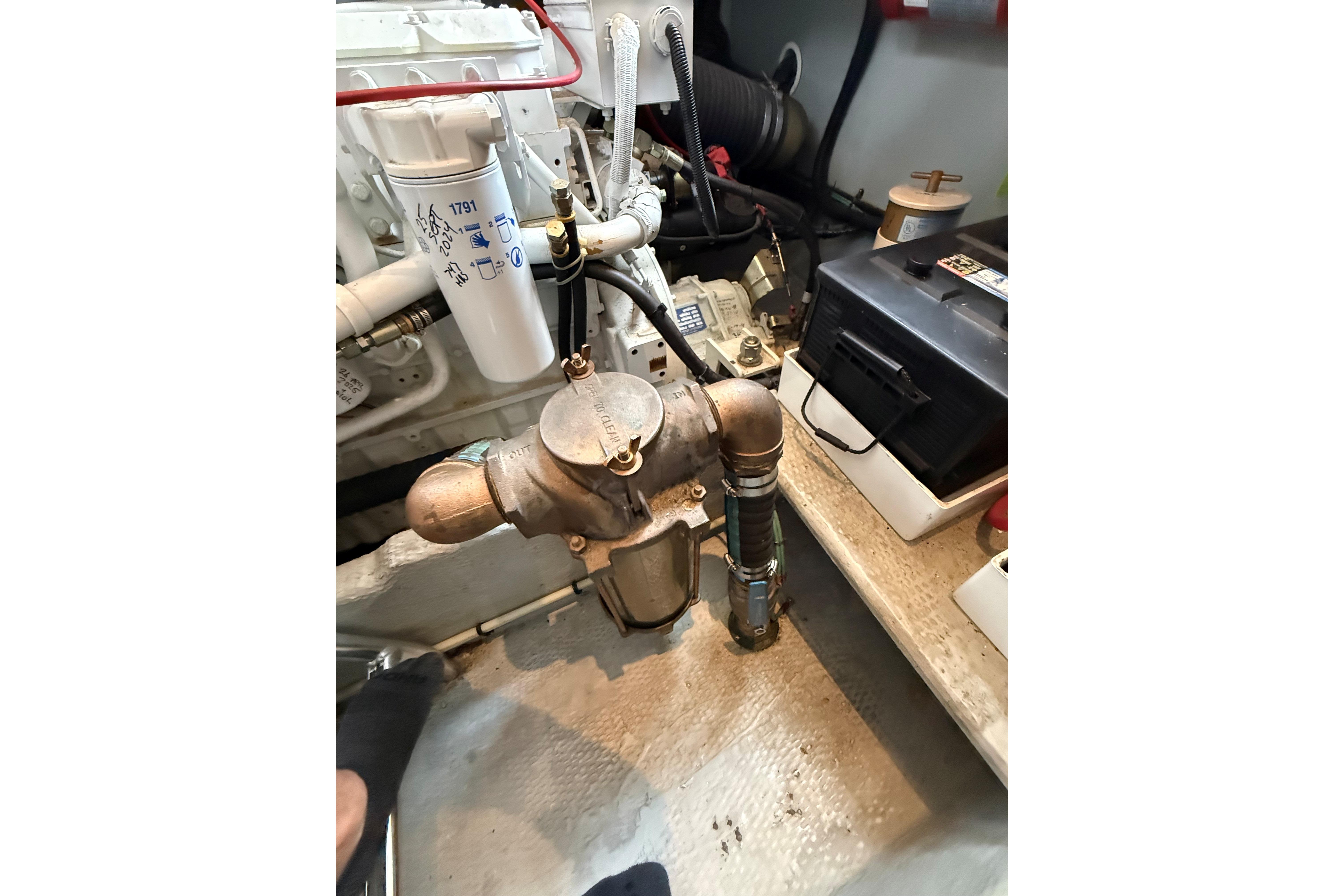 Engine room of 1999 Mainship 350 Trawler with visible components and battery.