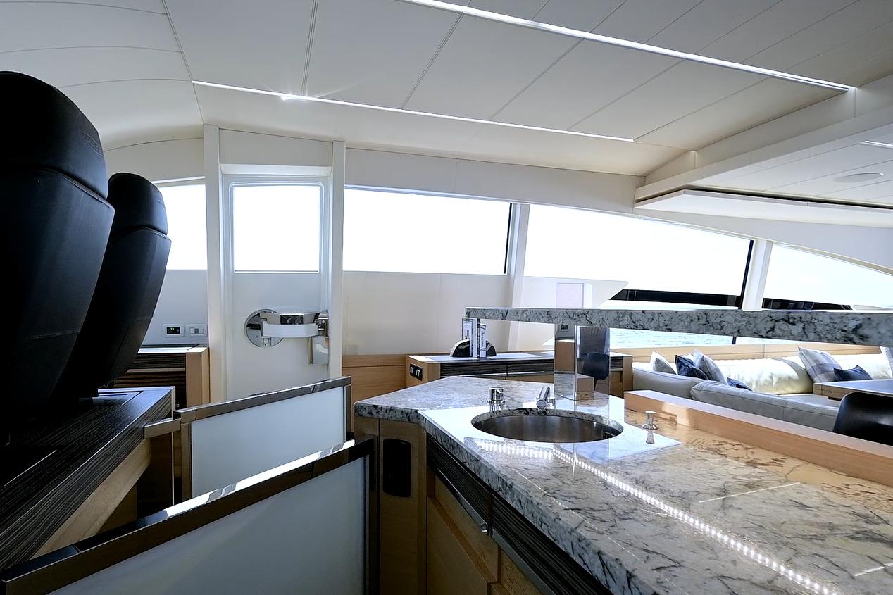 Luxurious interior of a 2015 Pershing 92 yacht with modern design and marble countertops.