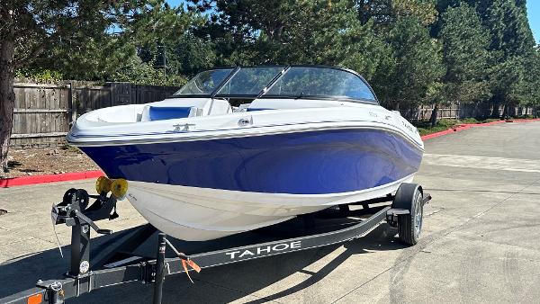 2024 Tahoe 200 S boat on trailer, blue and white, parked outdoors.