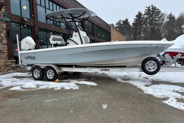 2026 Mako 24 APEX boat on trailer, parked in snowy outdoor setting.